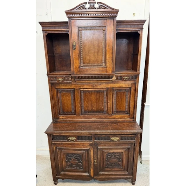 A carved oak court cupboard featuring a pull down bureau H20...