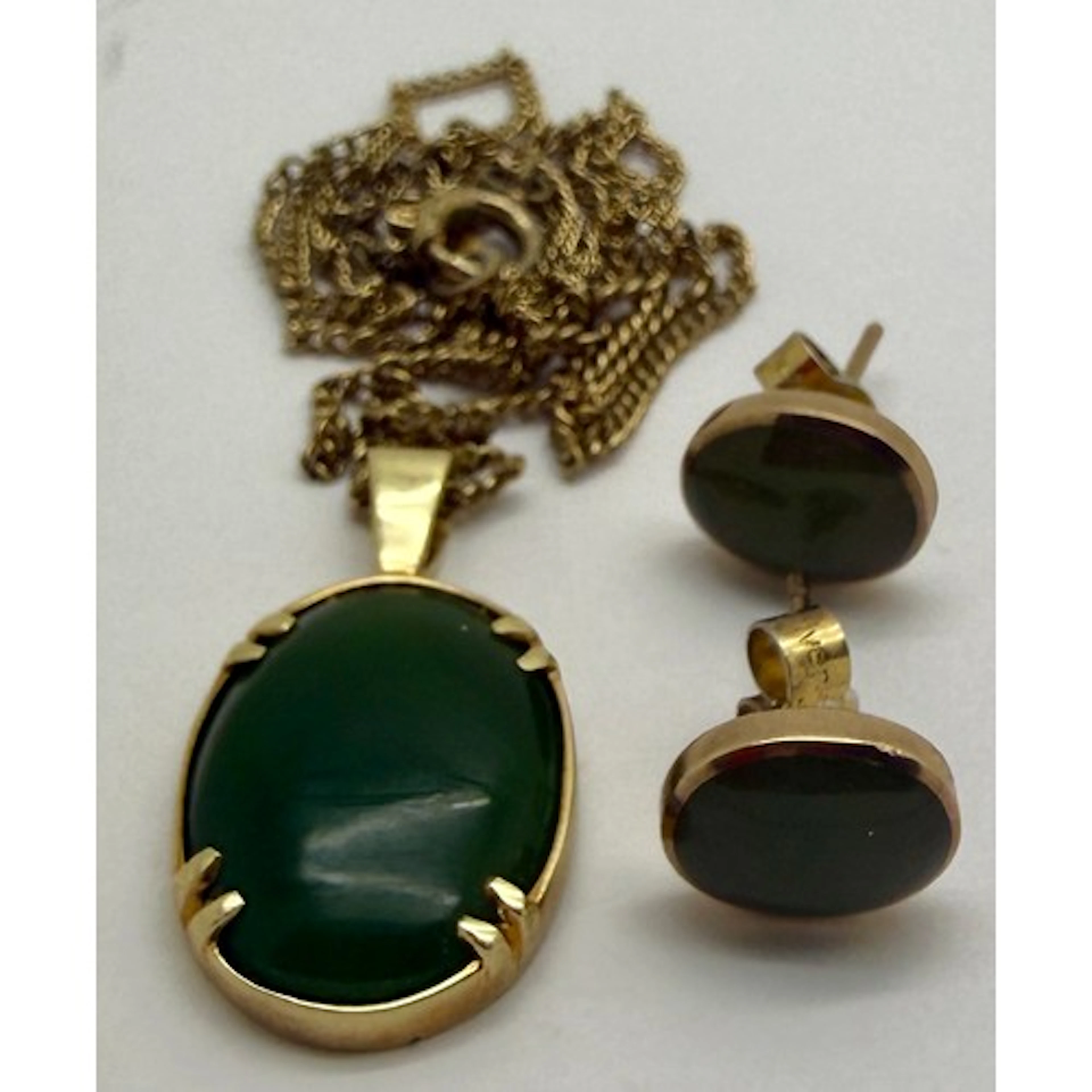 A 14 carat gold mounted green stone pendant (chain not gold)...
