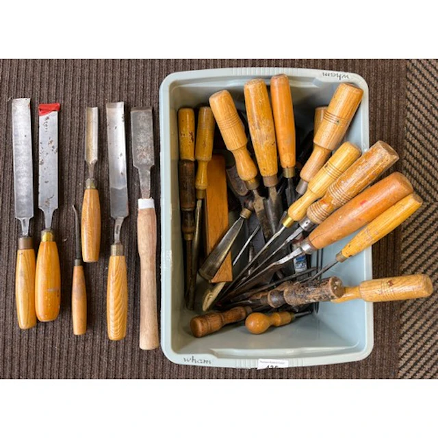 Collection of wood-handled chisels and other tools.
