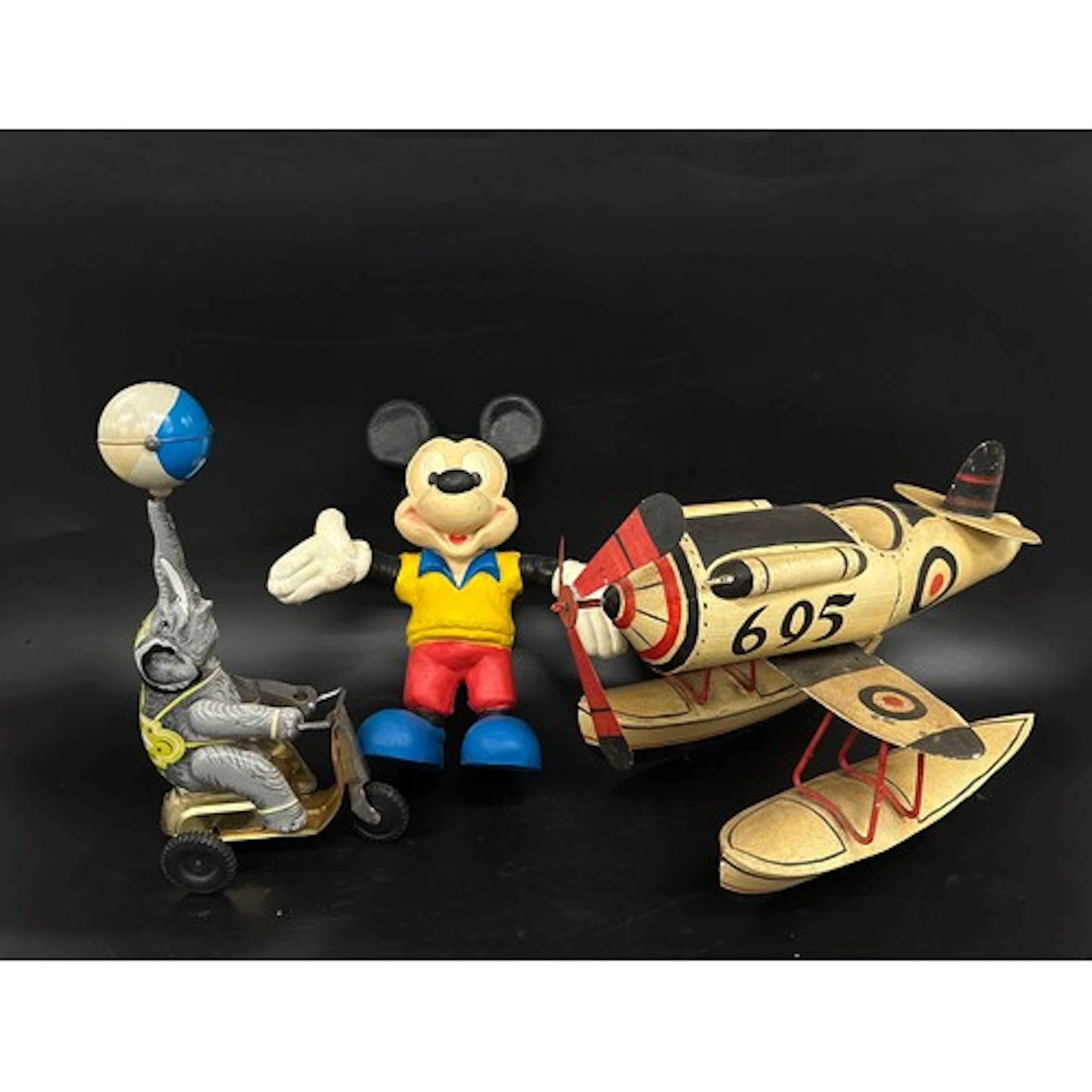 A Mickey Mouse bendy toy, a tin-plate model plane and a cloc...