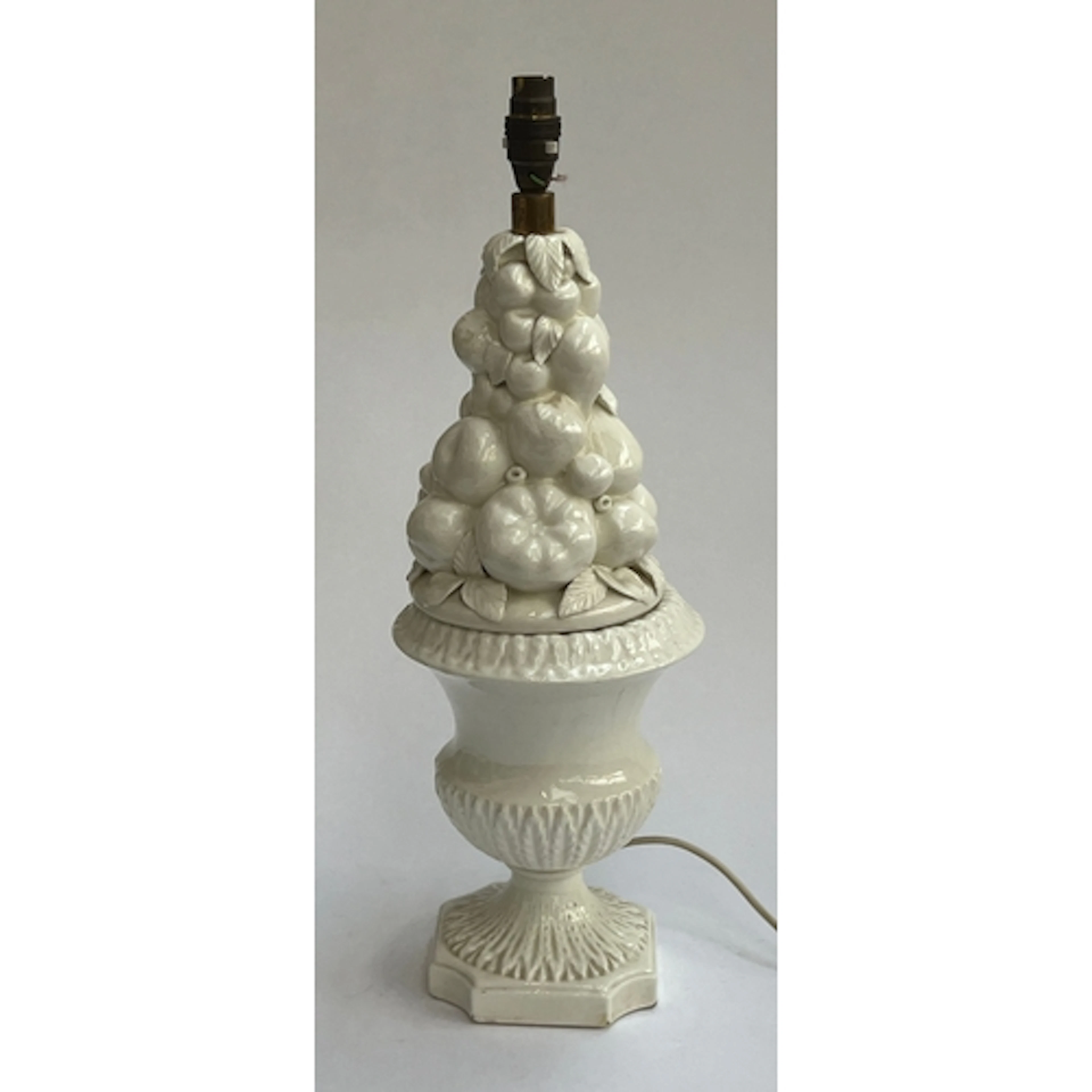 A white porcelain table lamp in a cornucopia of fruit shape,...