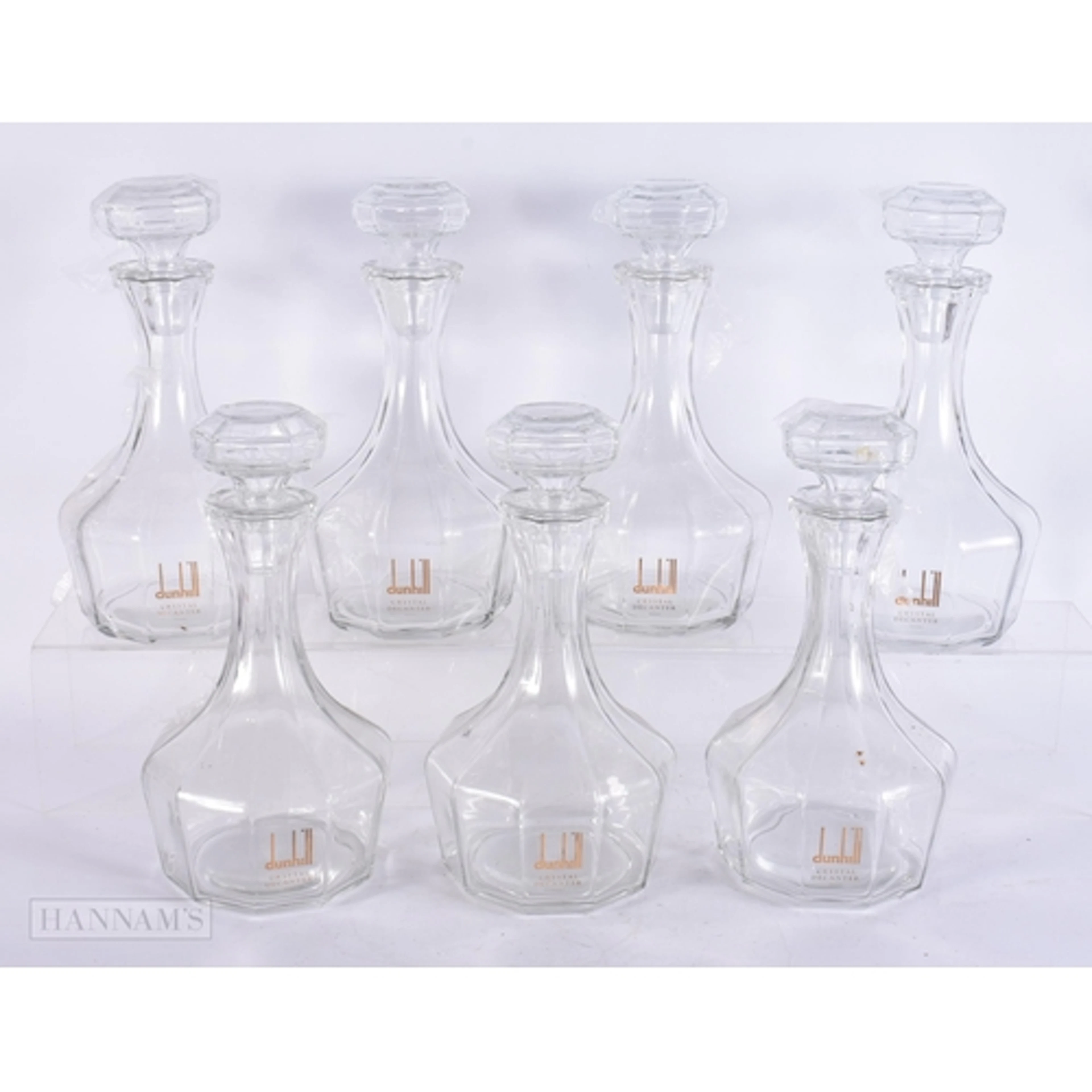 SEVEN DUNHILL CRYSTAL GLASS DECANTERS AND STOPPERS. 27 cm hi...