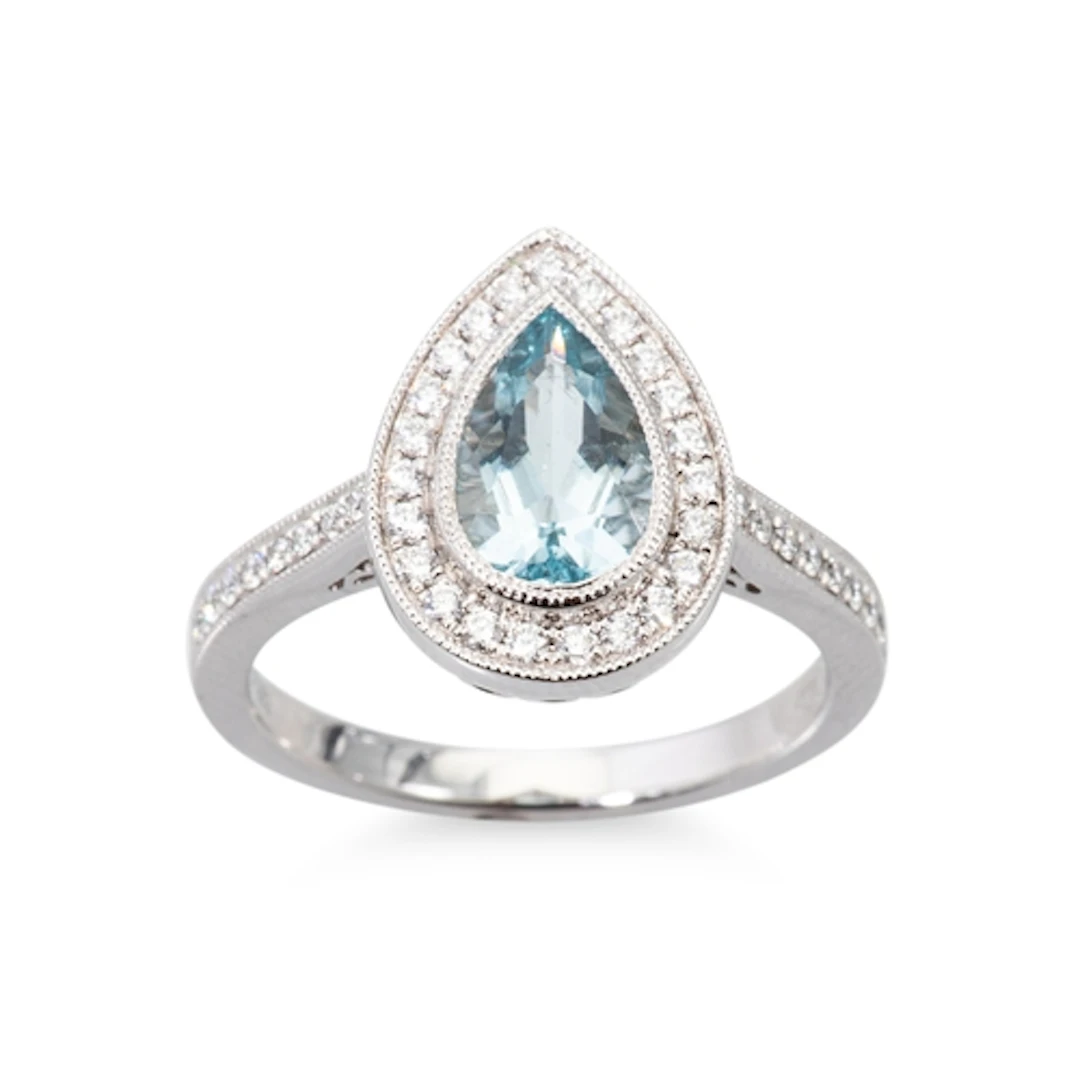 AN AQUAMARINE AND DIAMOND CLUSTER RING, the central pear cut...