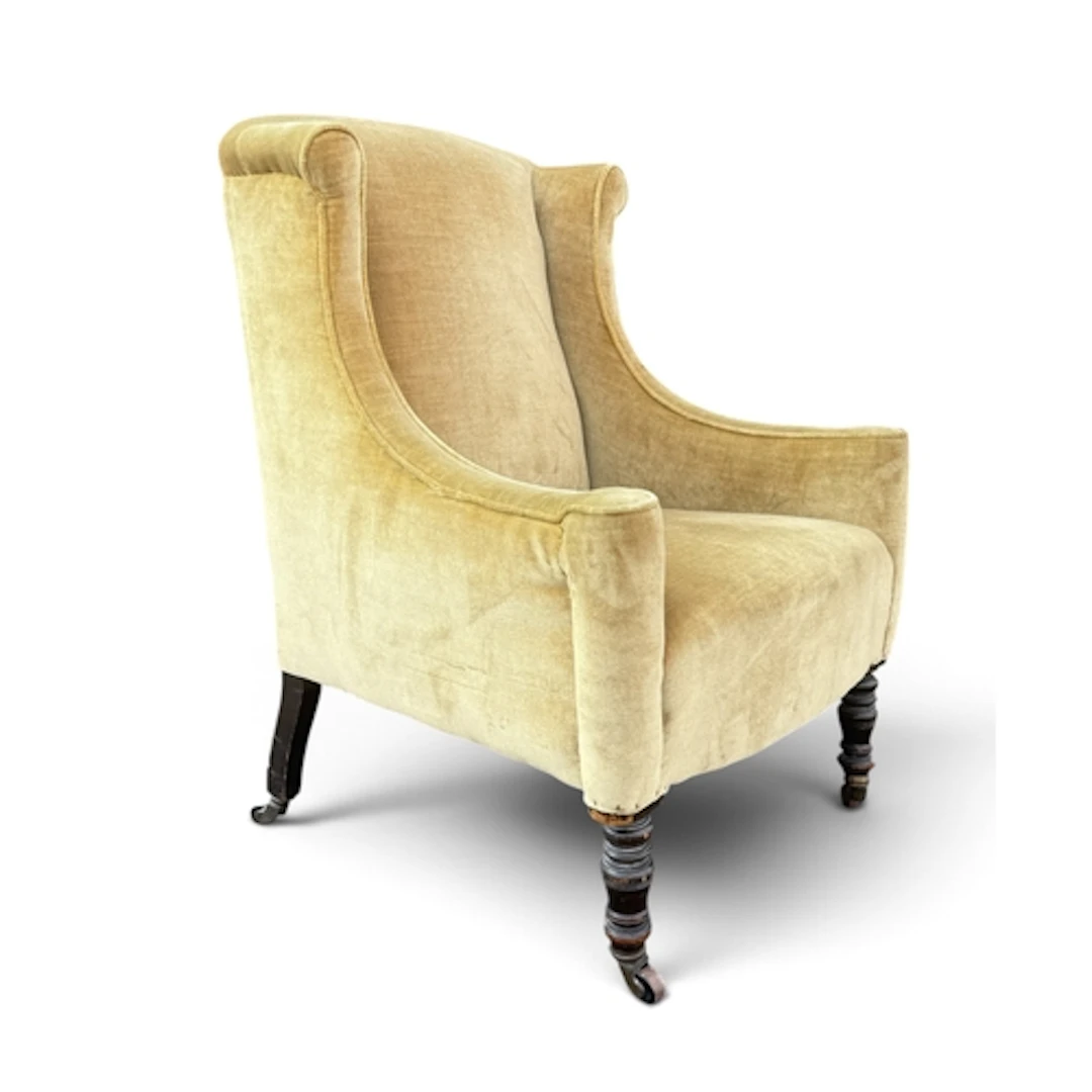 A VICTORIAN ARMCHAIR Raised on turned front legs and castors...