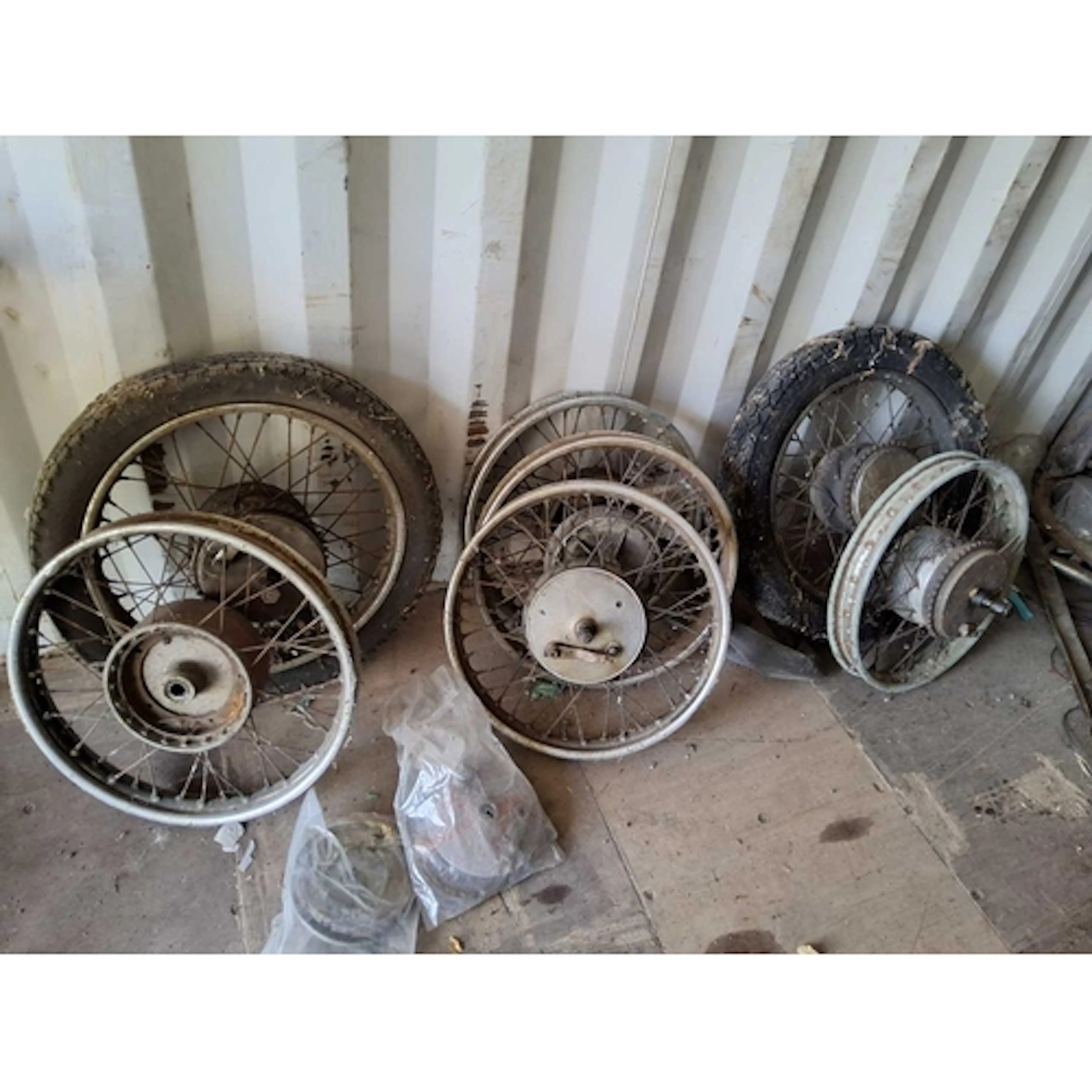 A COLLECTION OF VINTAGE SPOKED MOTORCYCLE WHEELS along with ...