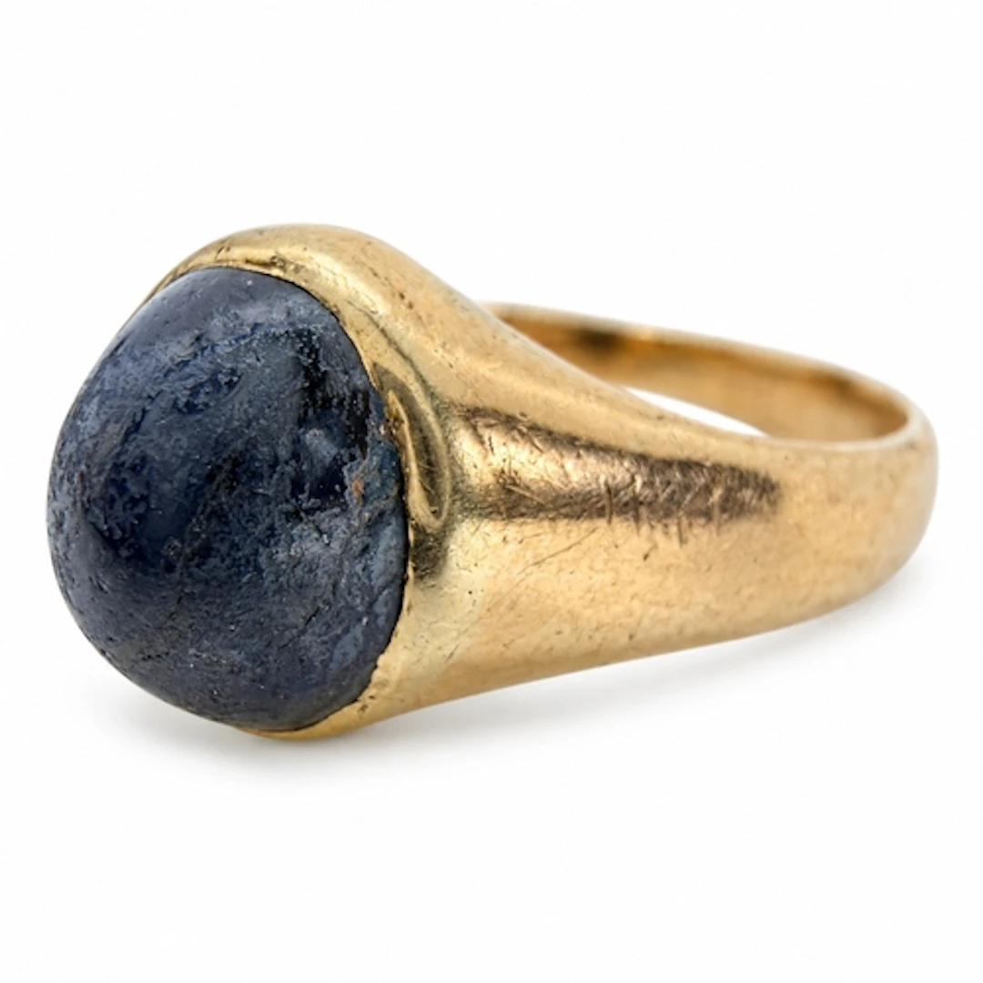 An antique unmarked gold ring set with a cabochon sapphire l...