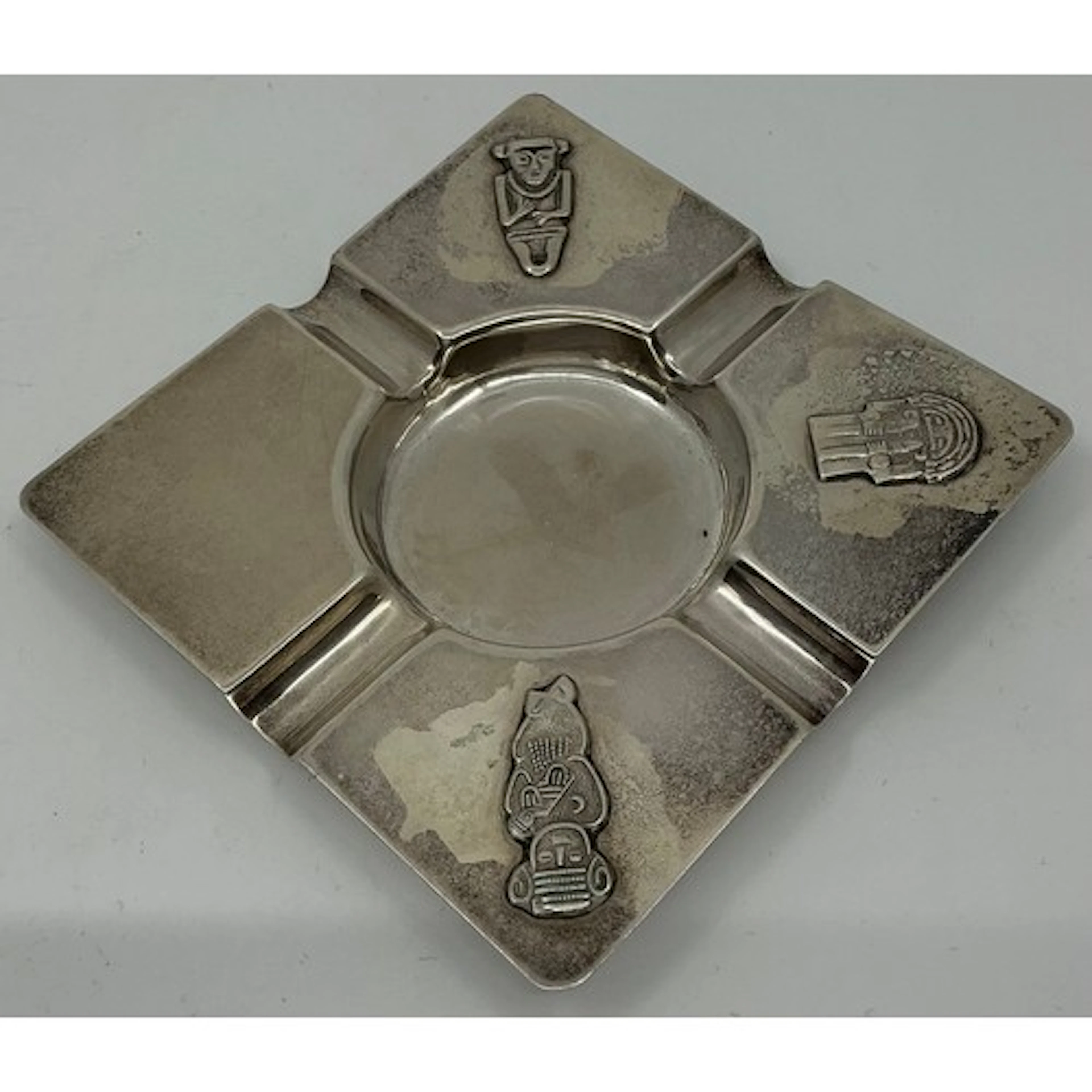 A South American silver ashtray decorated with Chilean deiti...