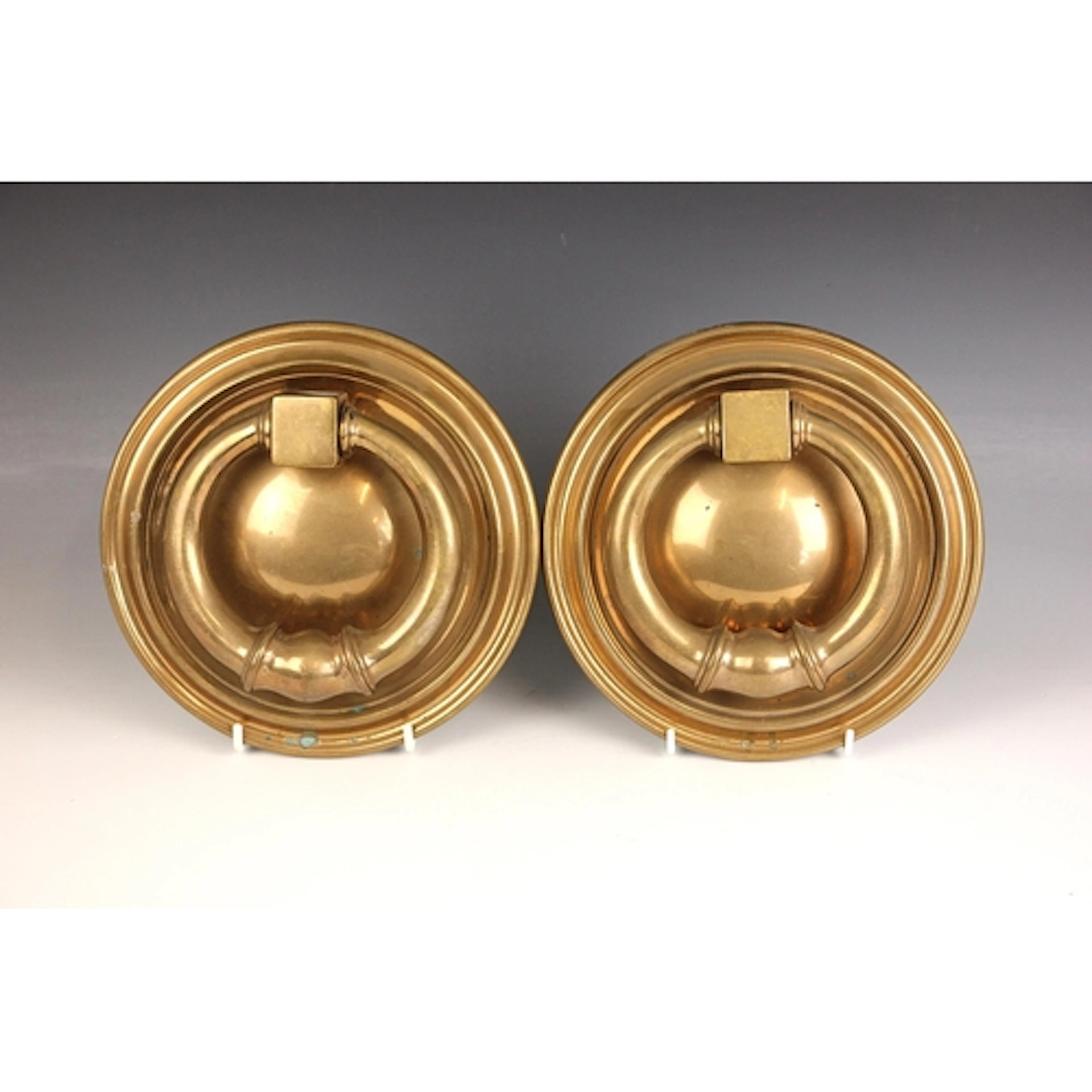 A pair of polished bronze door knockers, early 20th century,...