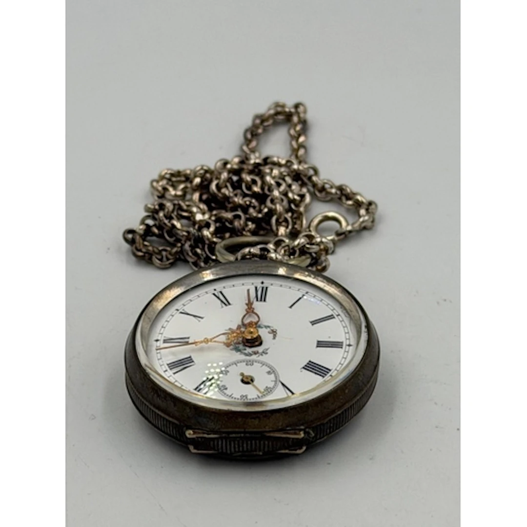 An ornate ladies silver pocket watch on silver belcher chain...