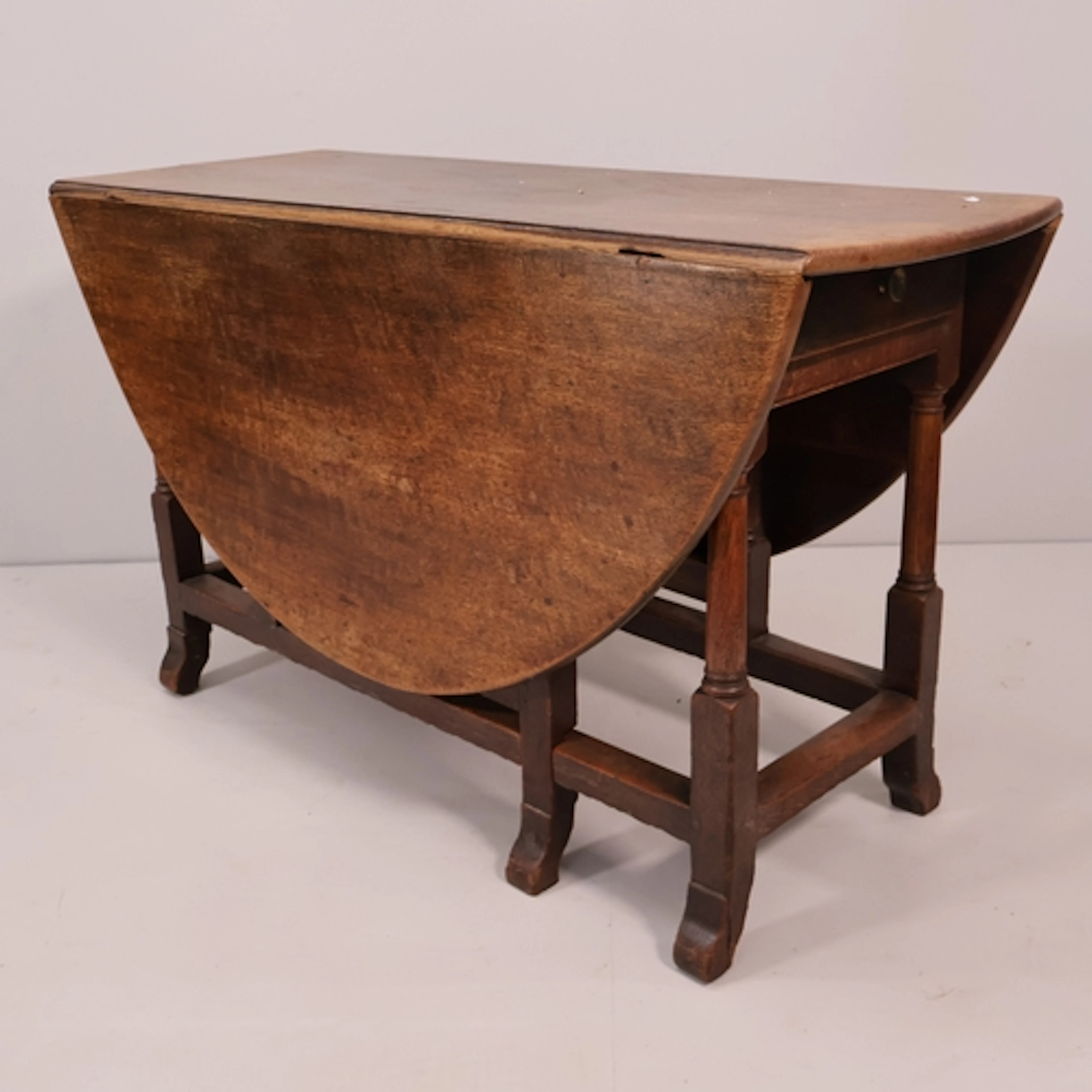 An early 20th century oak oval gateleg table with single end...