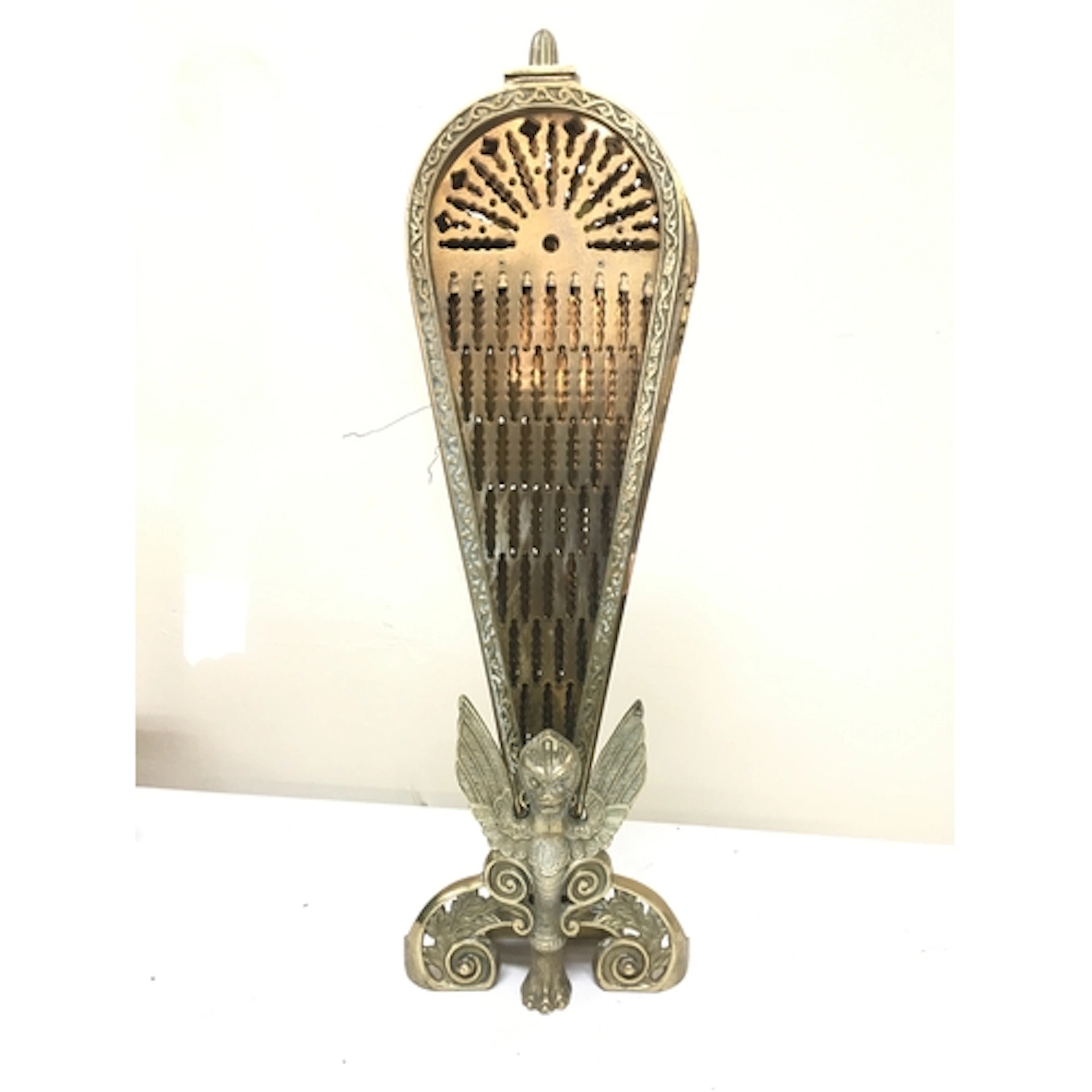 A vintage folding brass peacock fireplace screen featuring a...