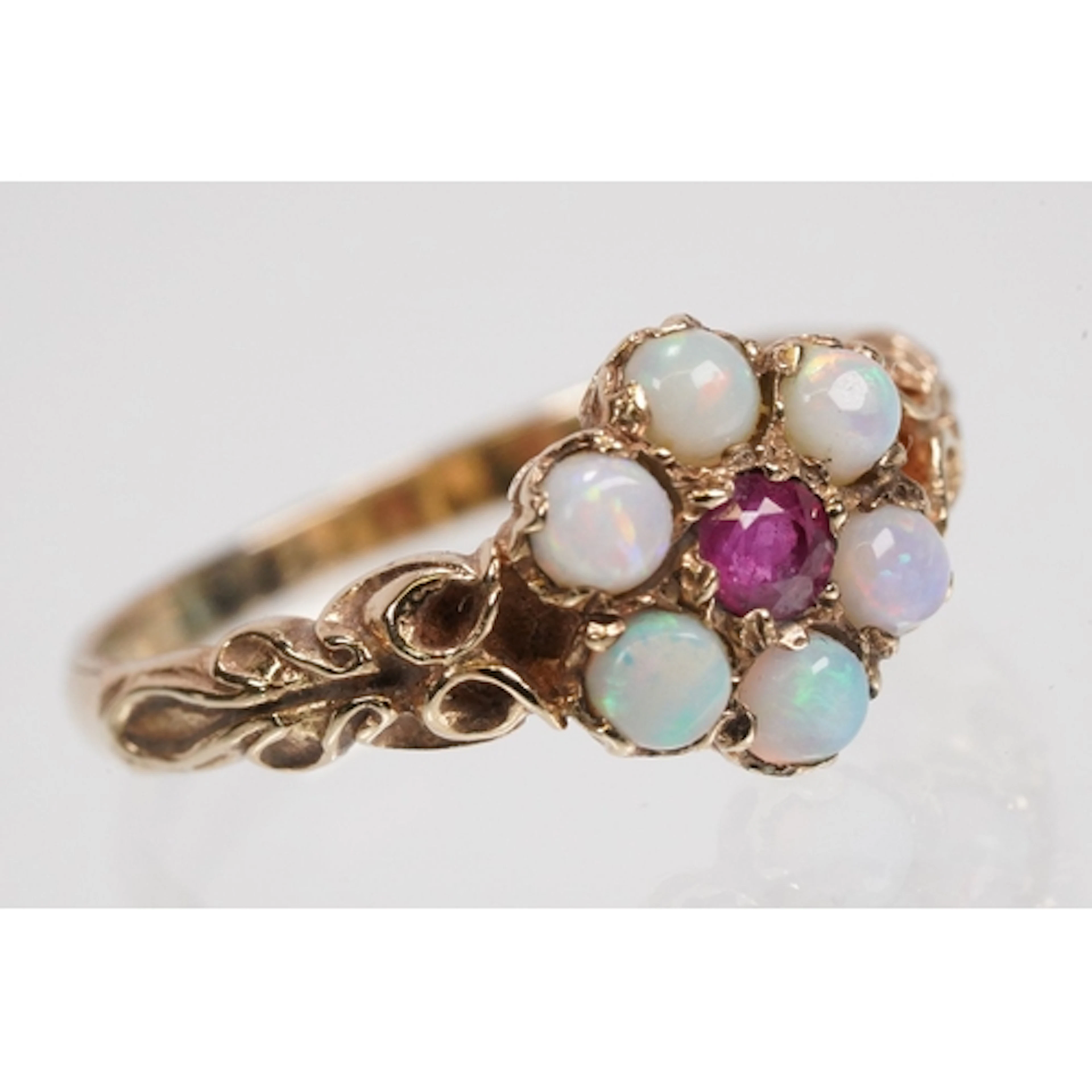9ct gold, opal and ruby cluster ring. The ring being set wit...