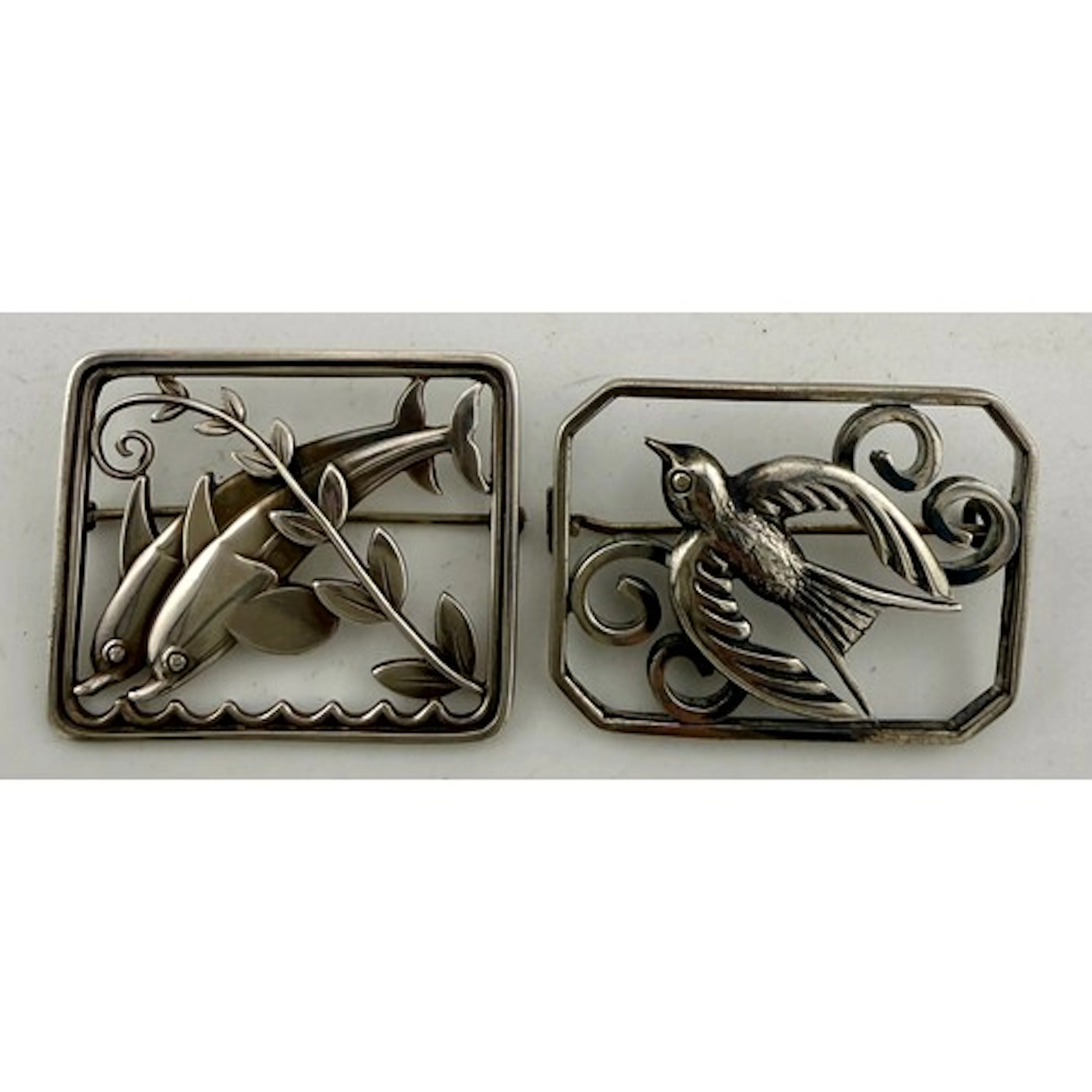 Two sterling silver brooches to include Georg Jensen dolphin...