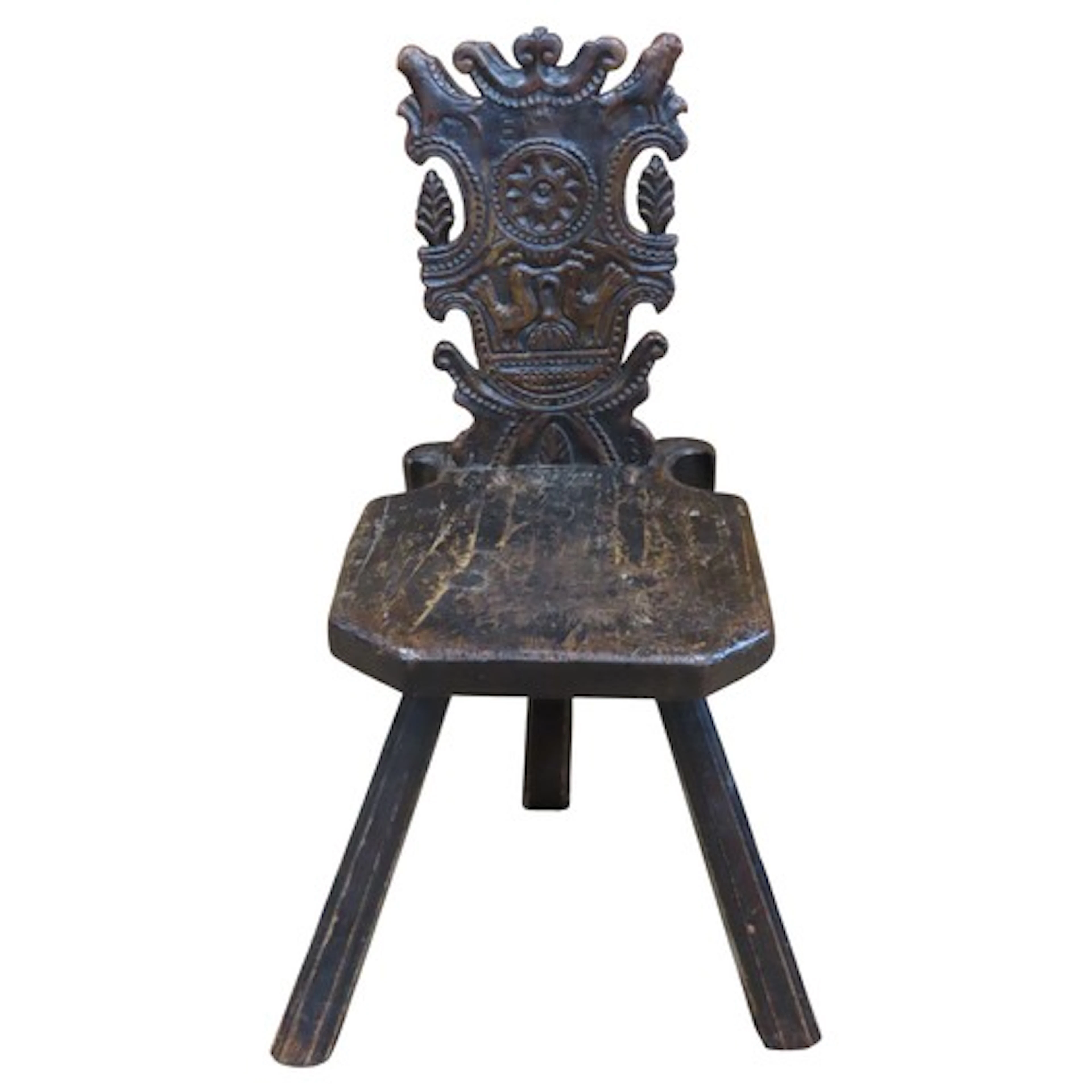 An antique back stool with carved bird and further detail an...