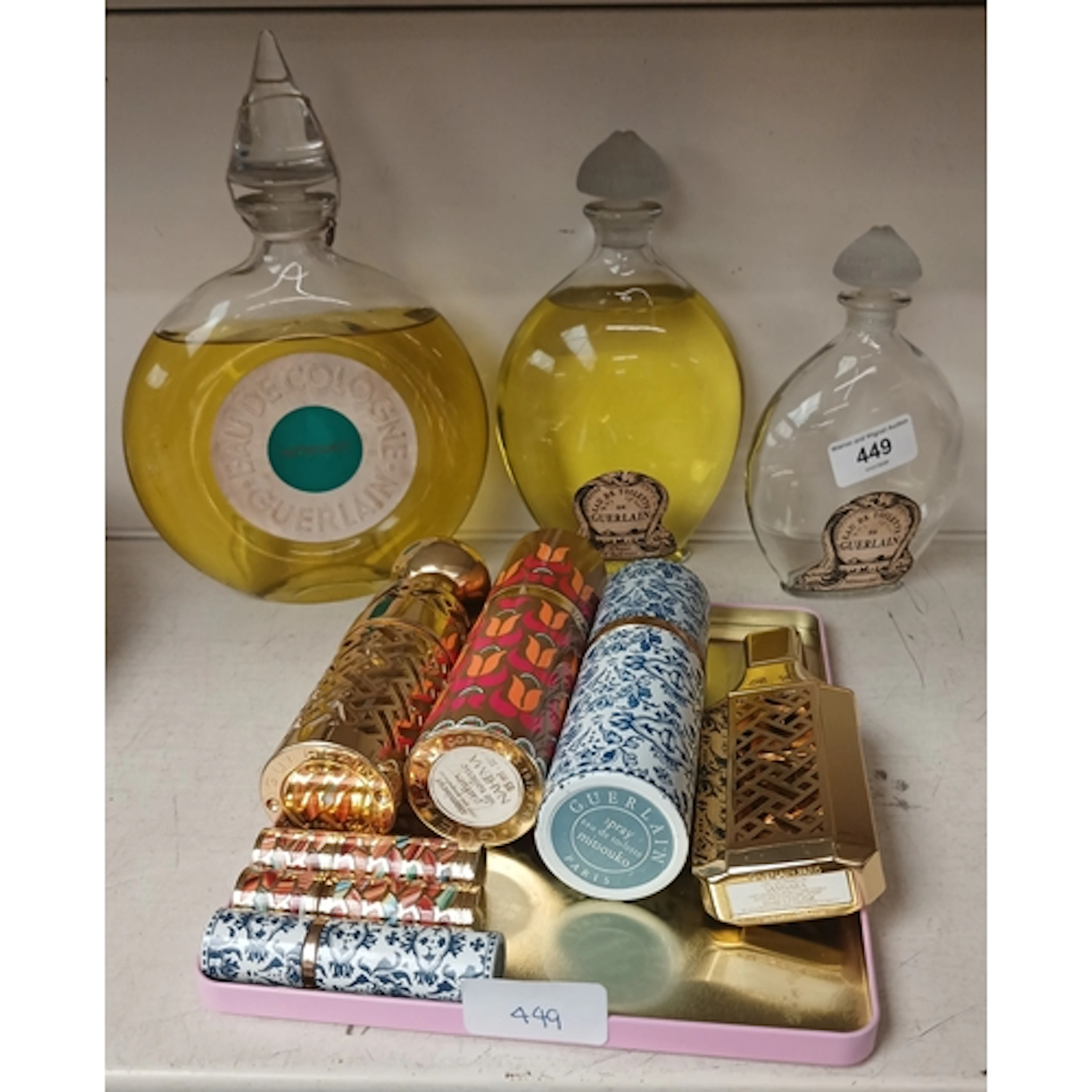 Guerlain, a group of perfume bottles and lipstick holders. G...