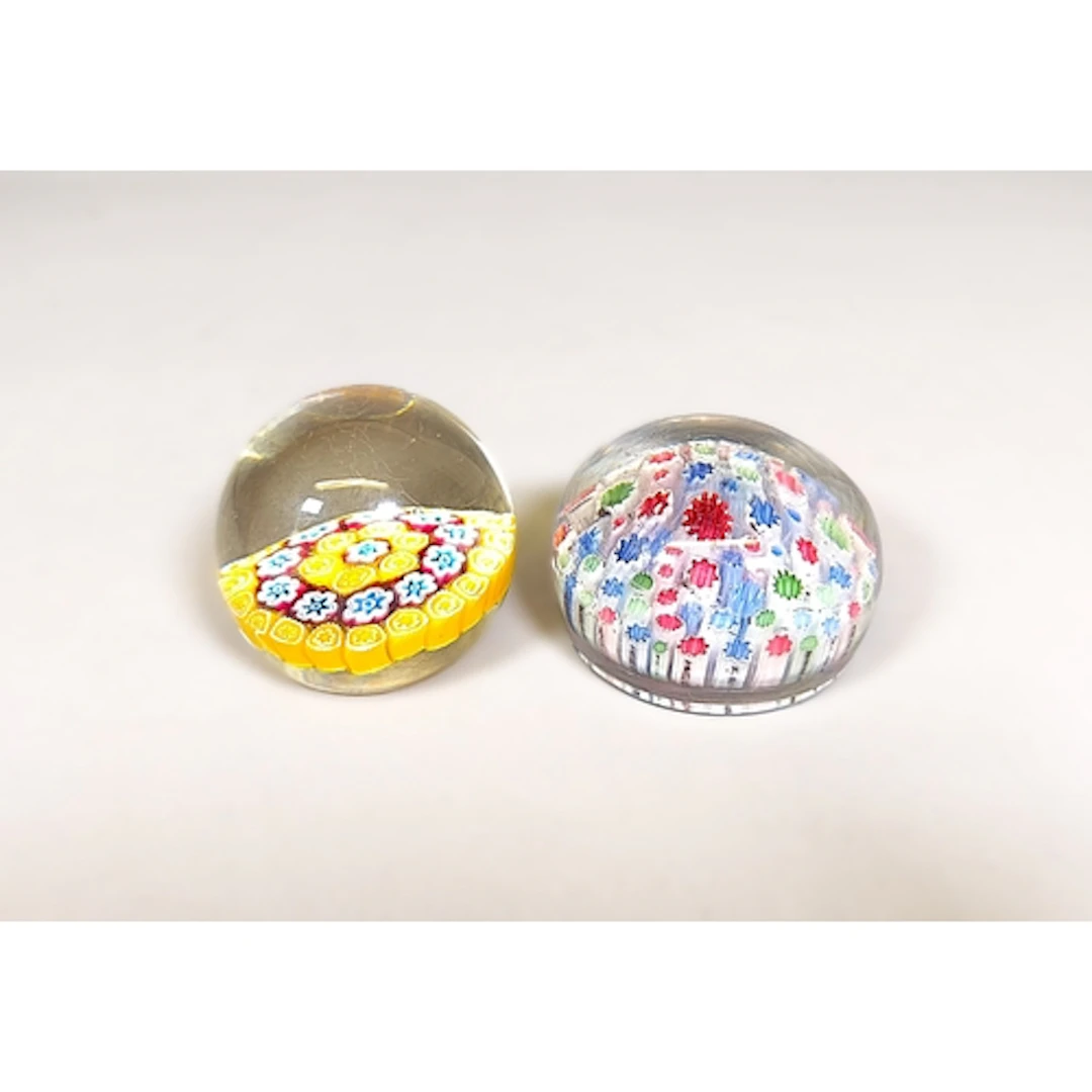 Two vintage millefiori glass paperweights, Designed with emb...