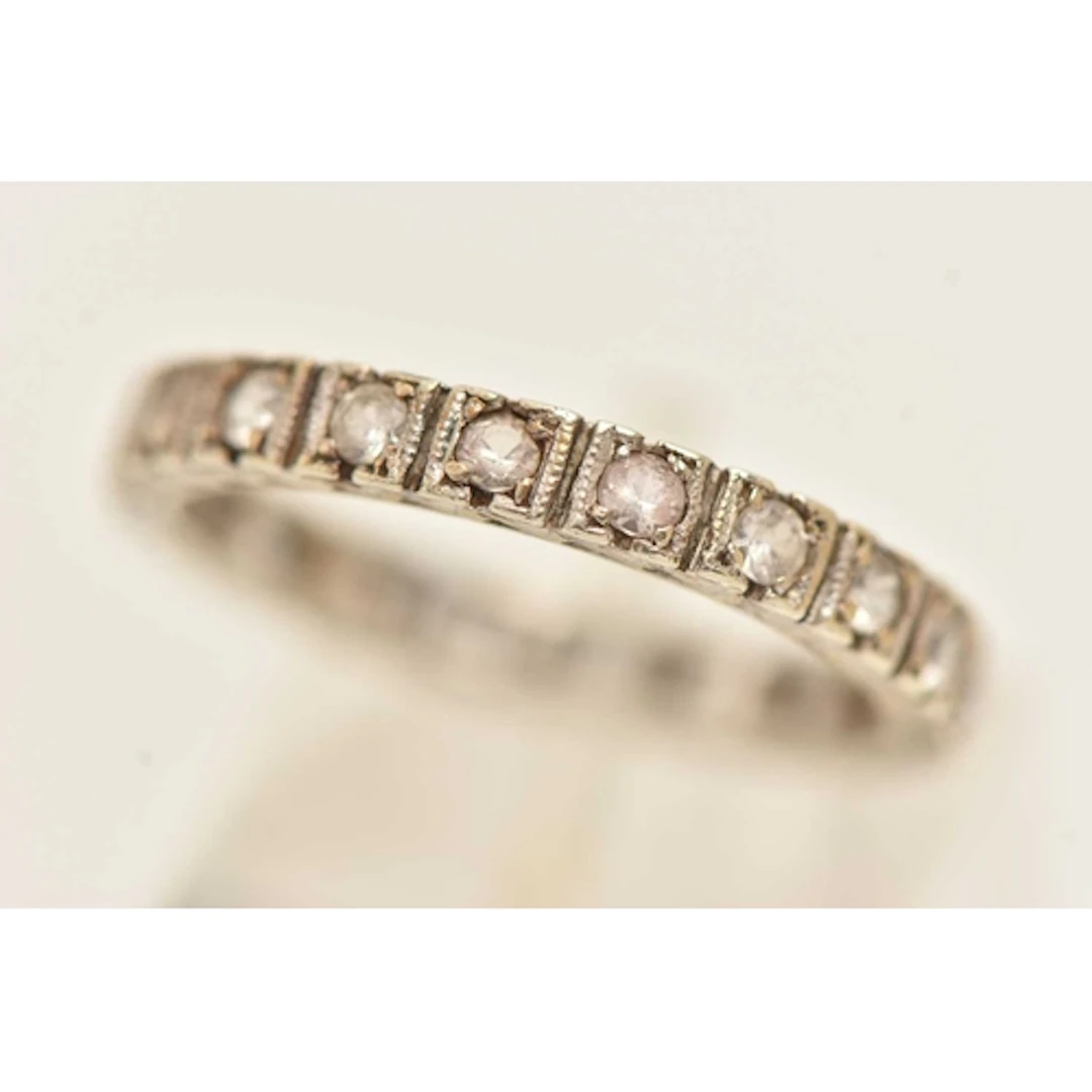A WHITE METAL COLOURLESS SPINEL SET FULL ETERNITY BAND RING,...