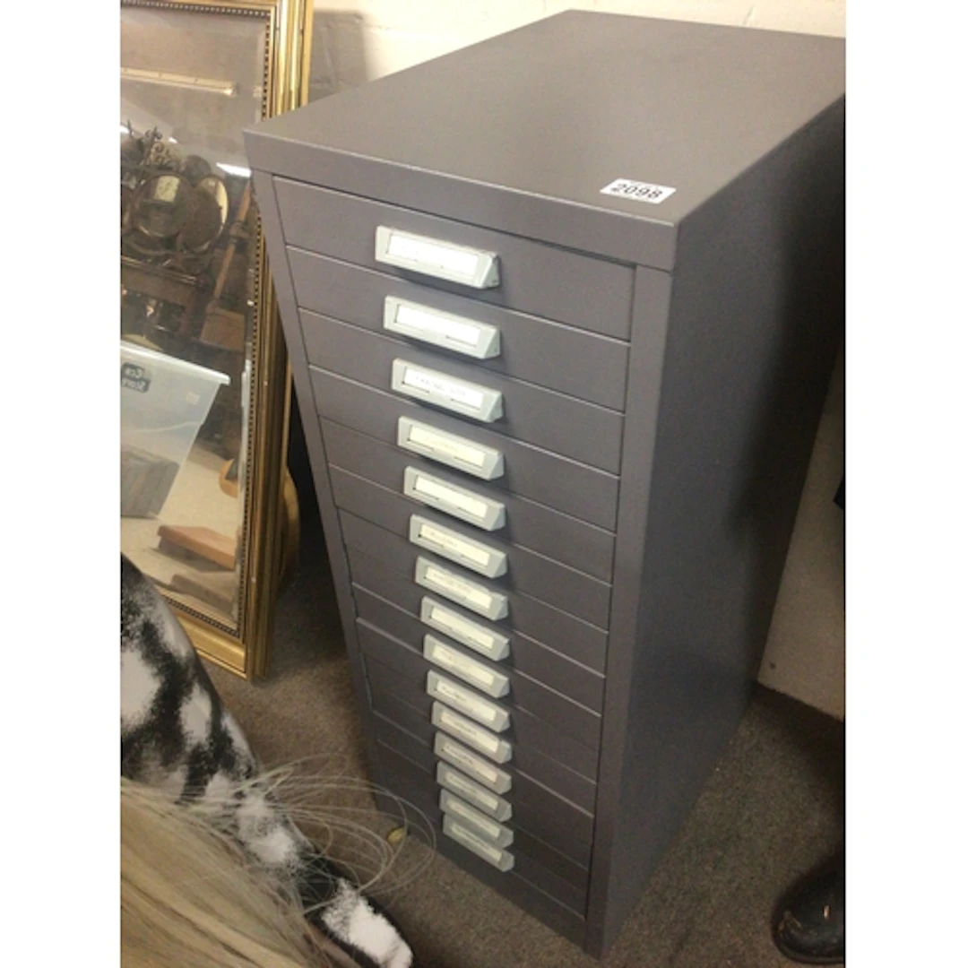 A metal collector cabinet with a flight of fifteen dra...