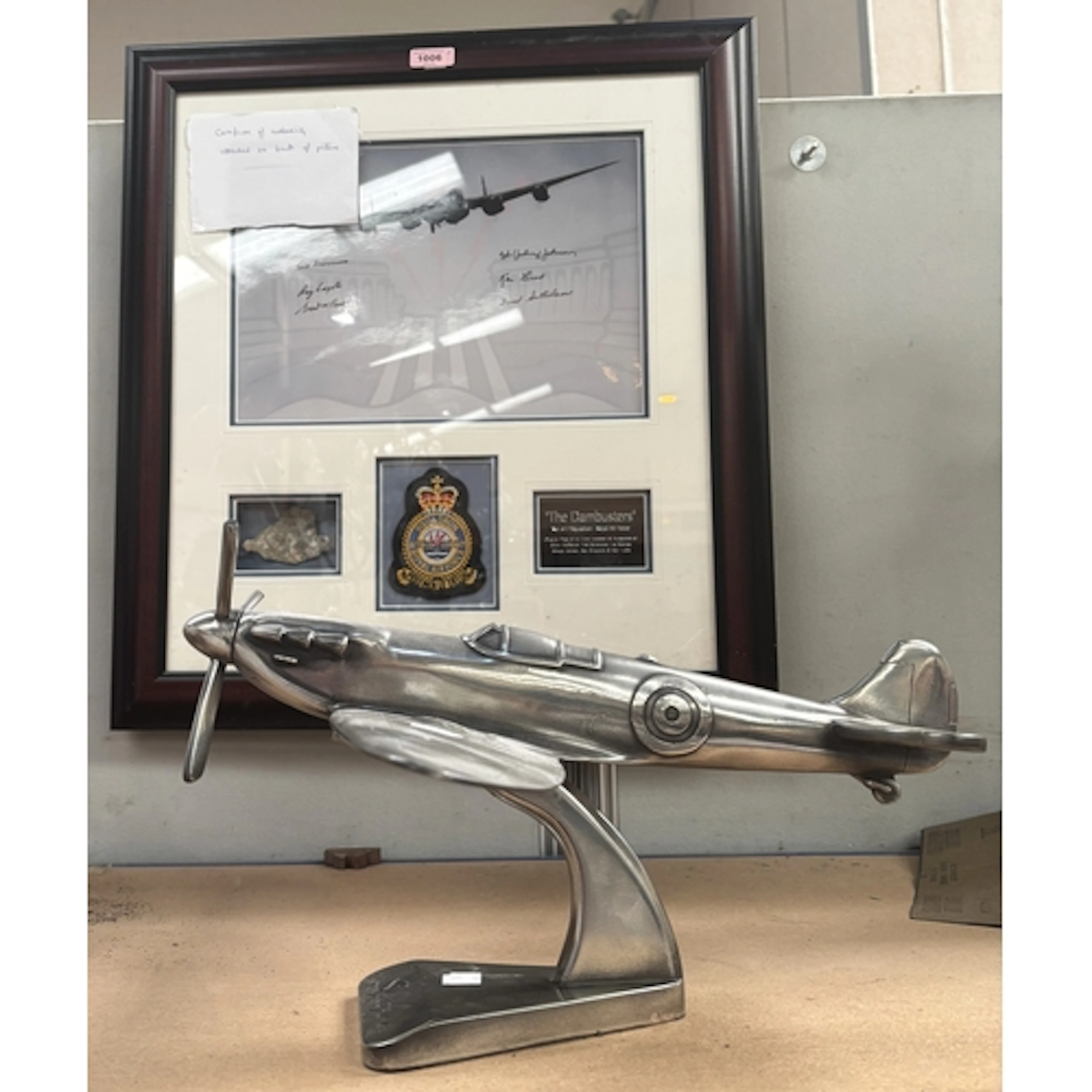 An aluminium model of a Spitfire on stand; a picture collage...
