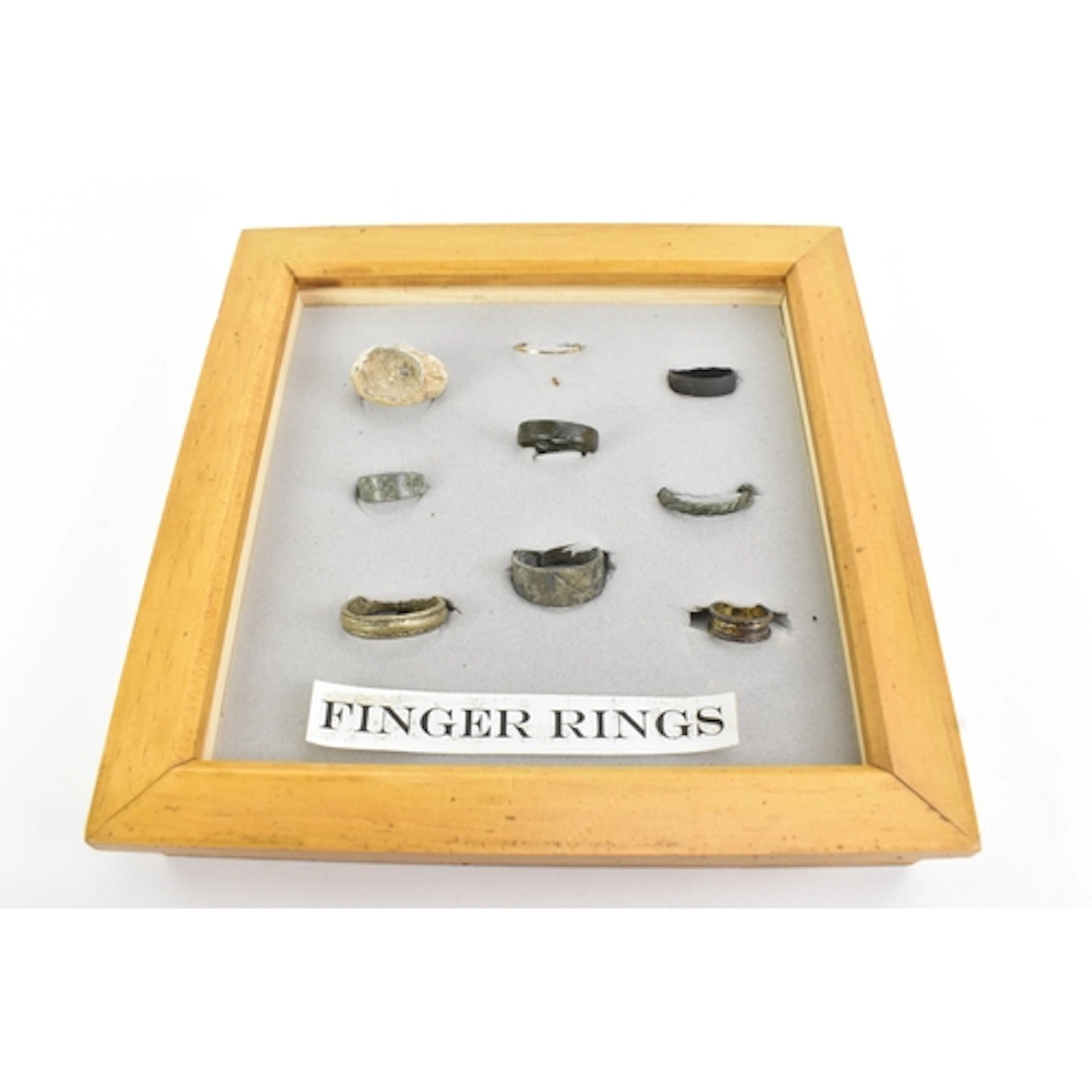 A framed group of early metal finger rings, bronze and coppe...