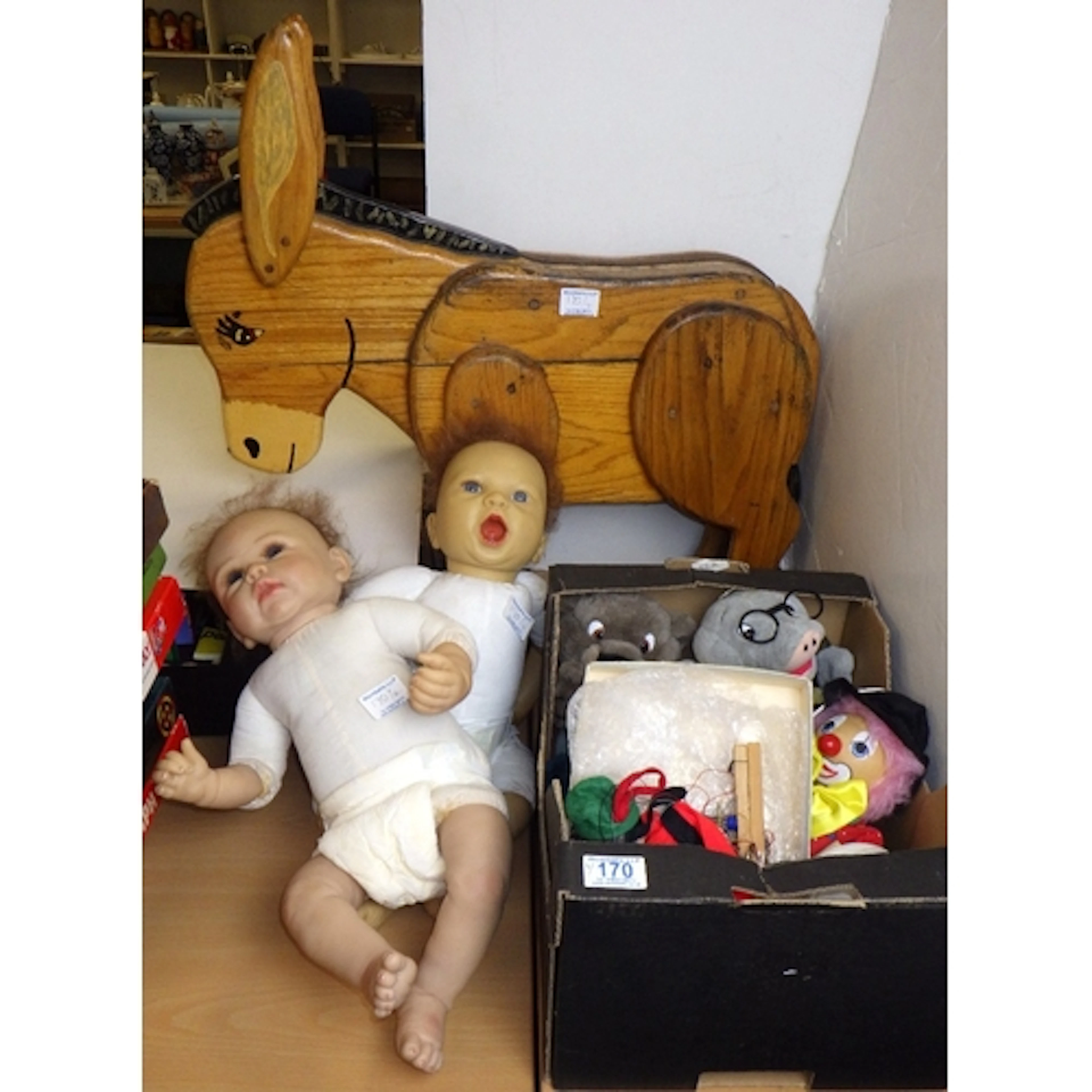 A wooden donkey together with a qty of various puppets and d...