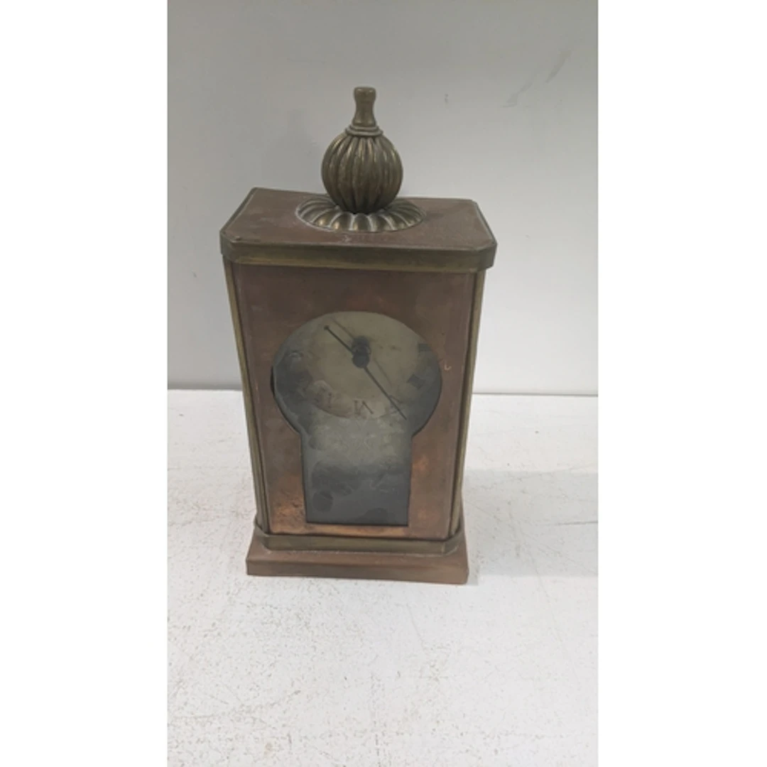 An arts and crafts copper and brass framed mantle clock havi...