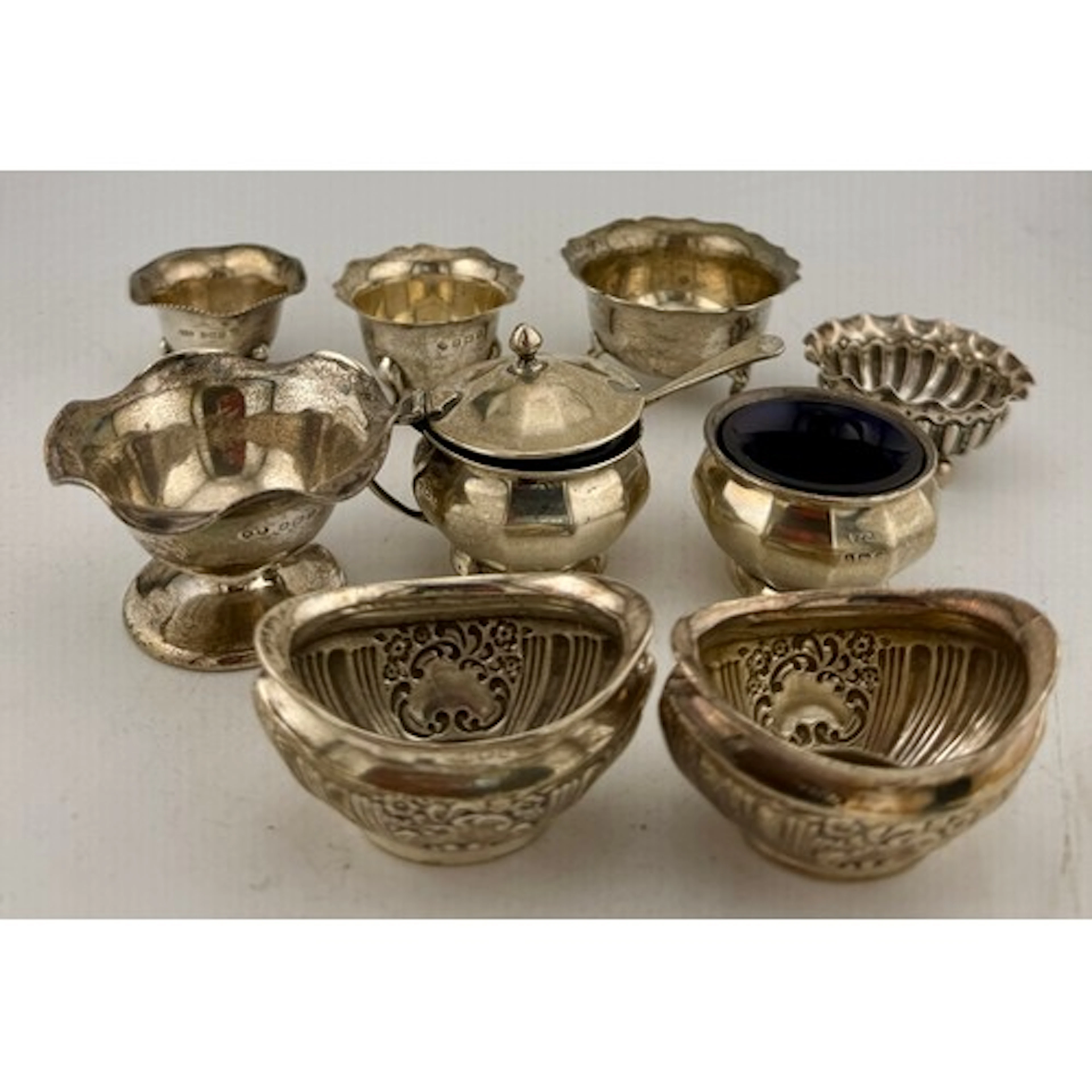 Eight hallmarked silver salts together with a lidded mustard...