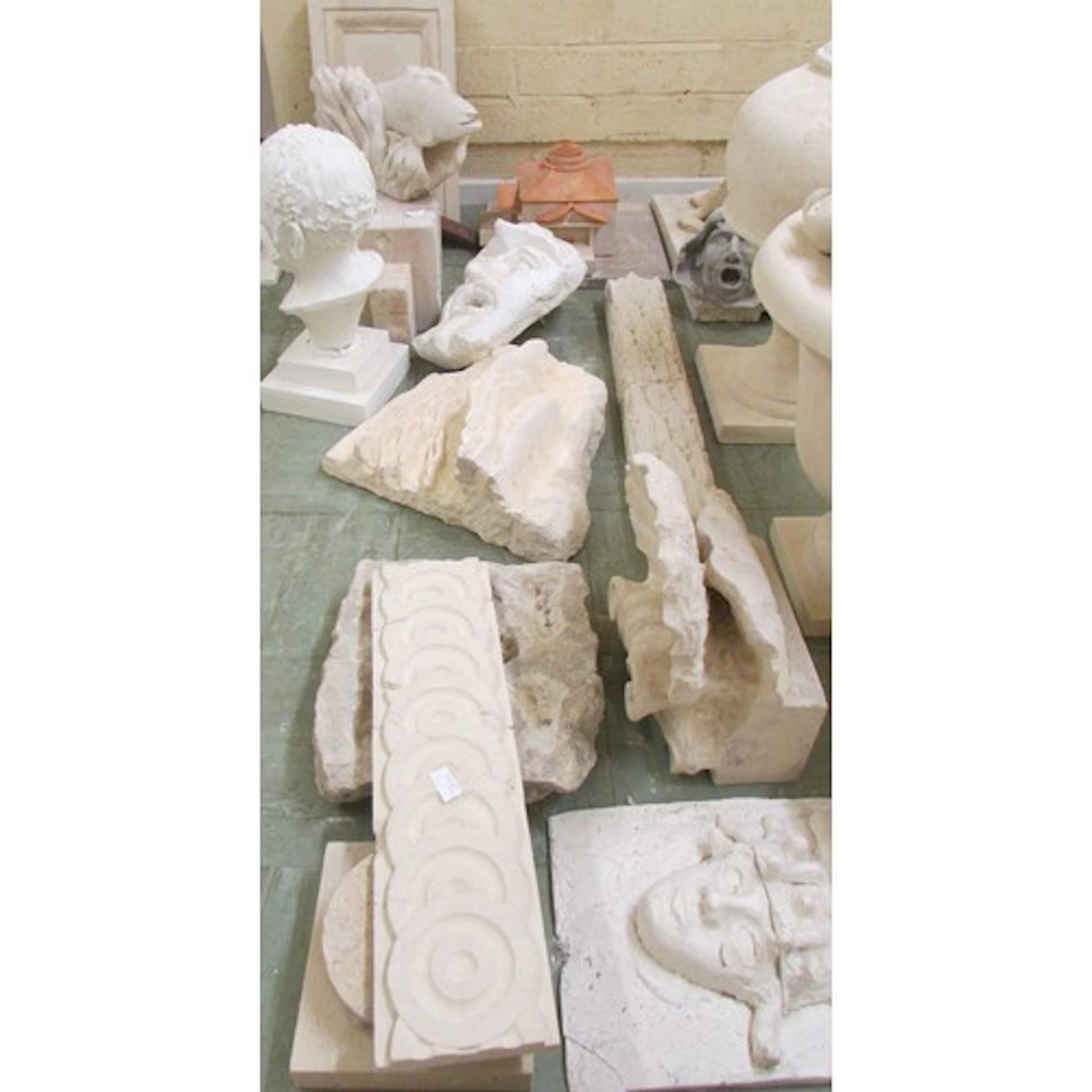 A collection of carved stone and composite items including a...