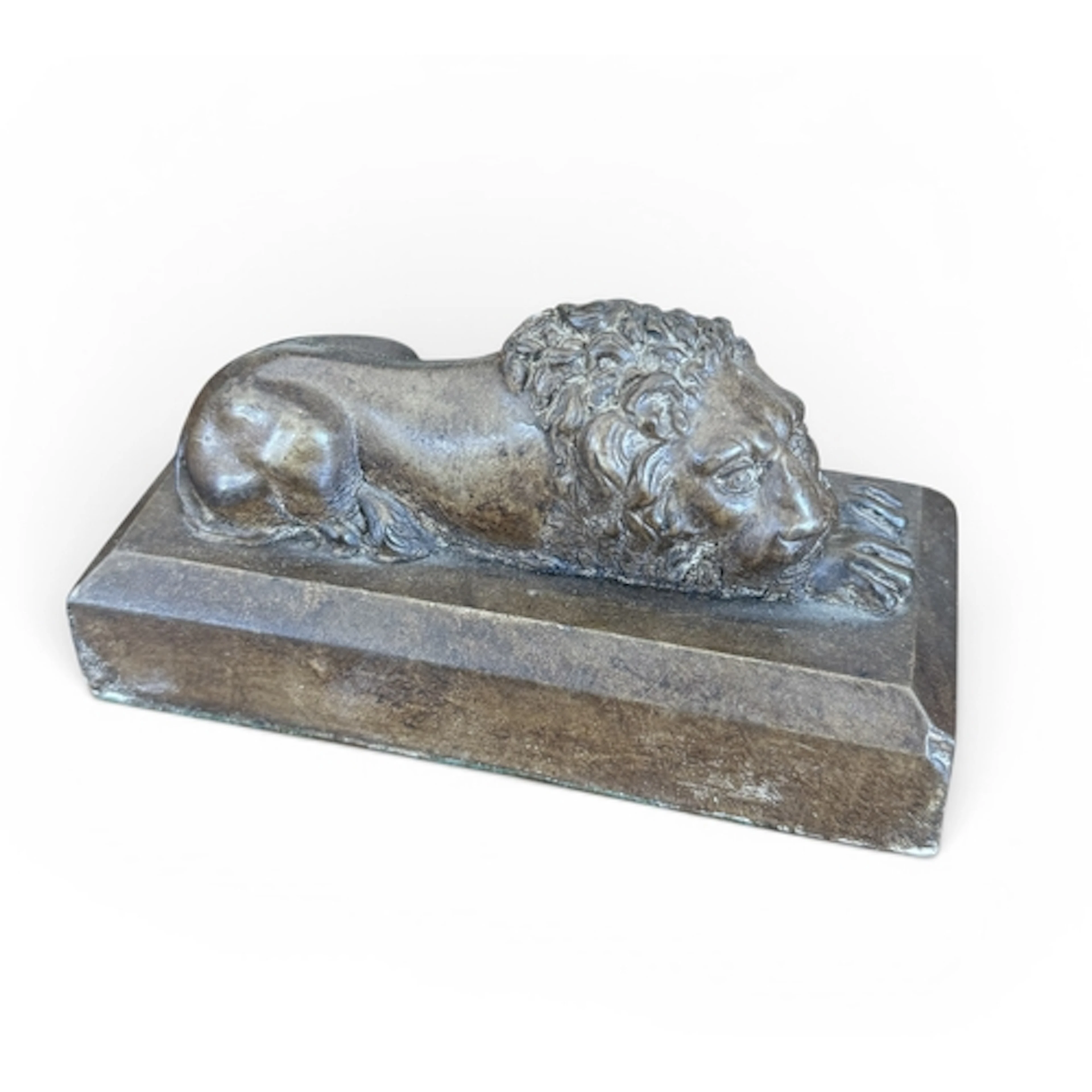 A GLAZED CERAMIC FIGURE OF A RECUMBENT LION