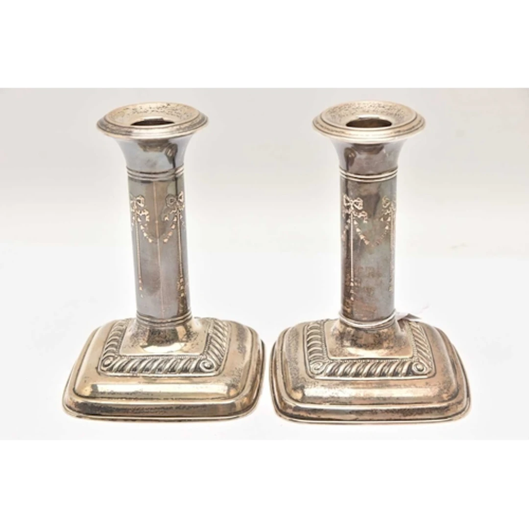 A PAIR OF EARLY 20TH CENTURY SILVER CANDLESTICKS, ribbon and...