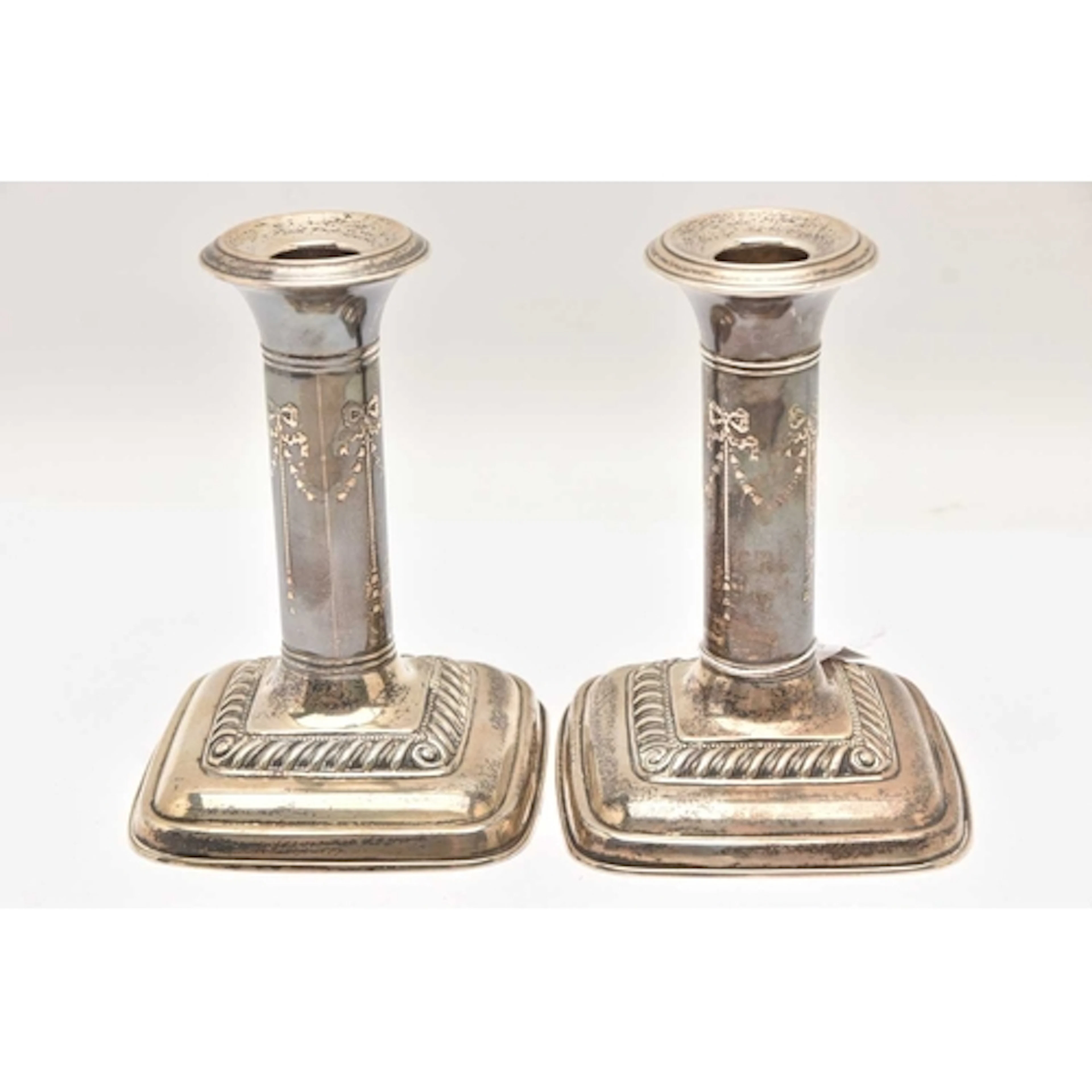 A PAIR OF EARLY 20TH CENTURY SILVER CANDLESTICKS, ribbon and...