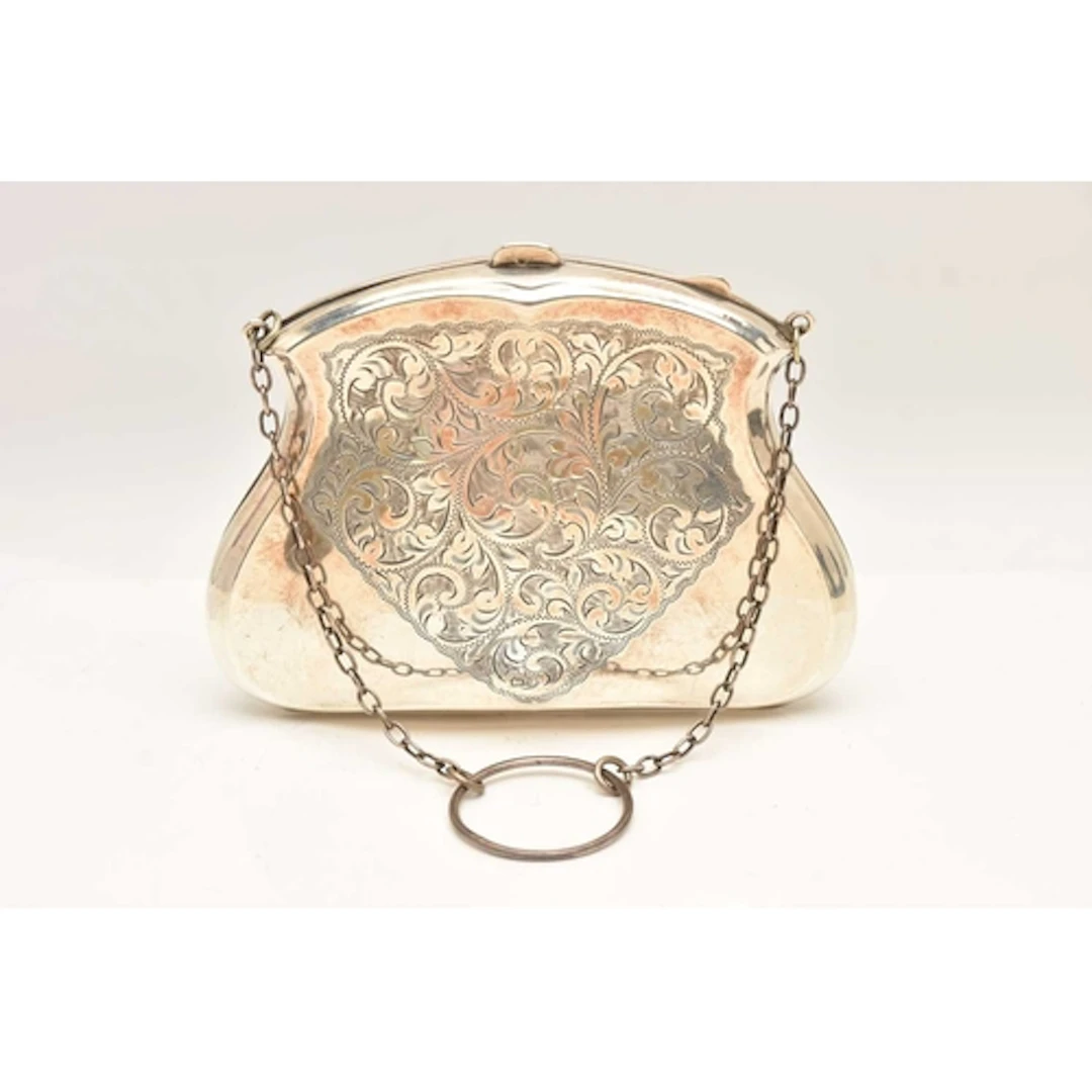 AN EARLY 20TH CENTURY SILVER PURSE, decorated with a scrolli...