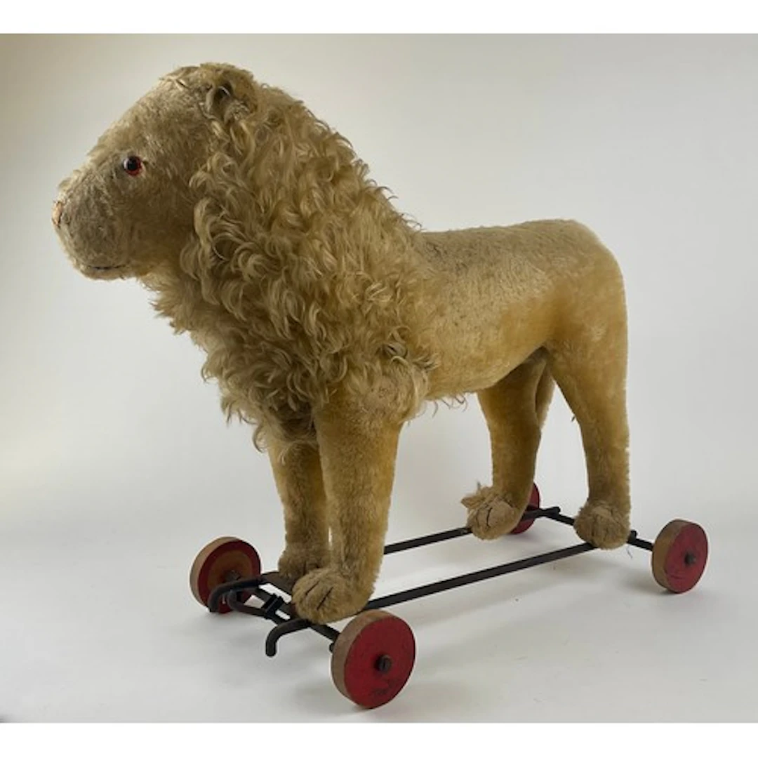 A 1920s Steiff lion on wheels, with blonde mohair, yellow an...