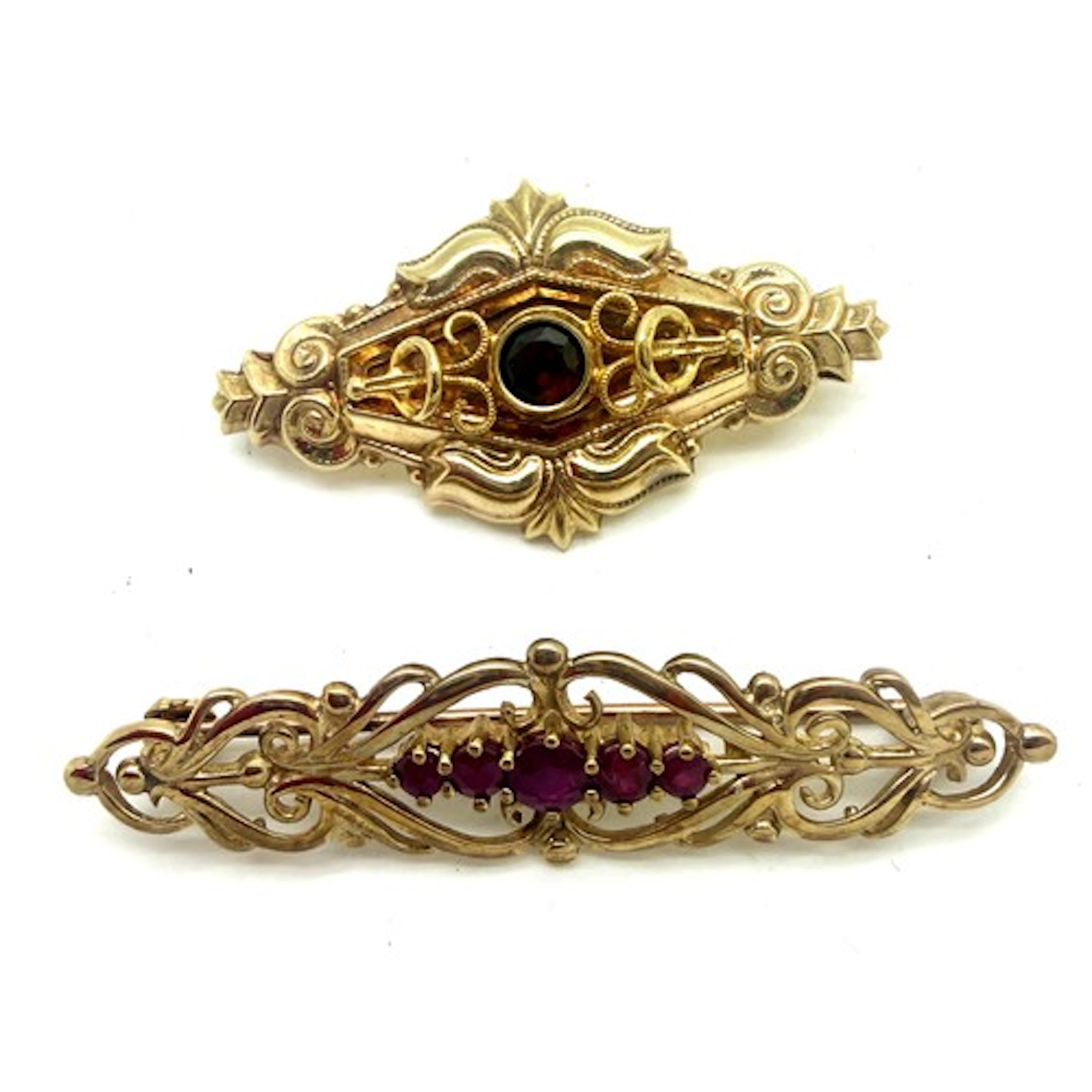Two 9 carat gold bar brooches set with red stones. Total wei...