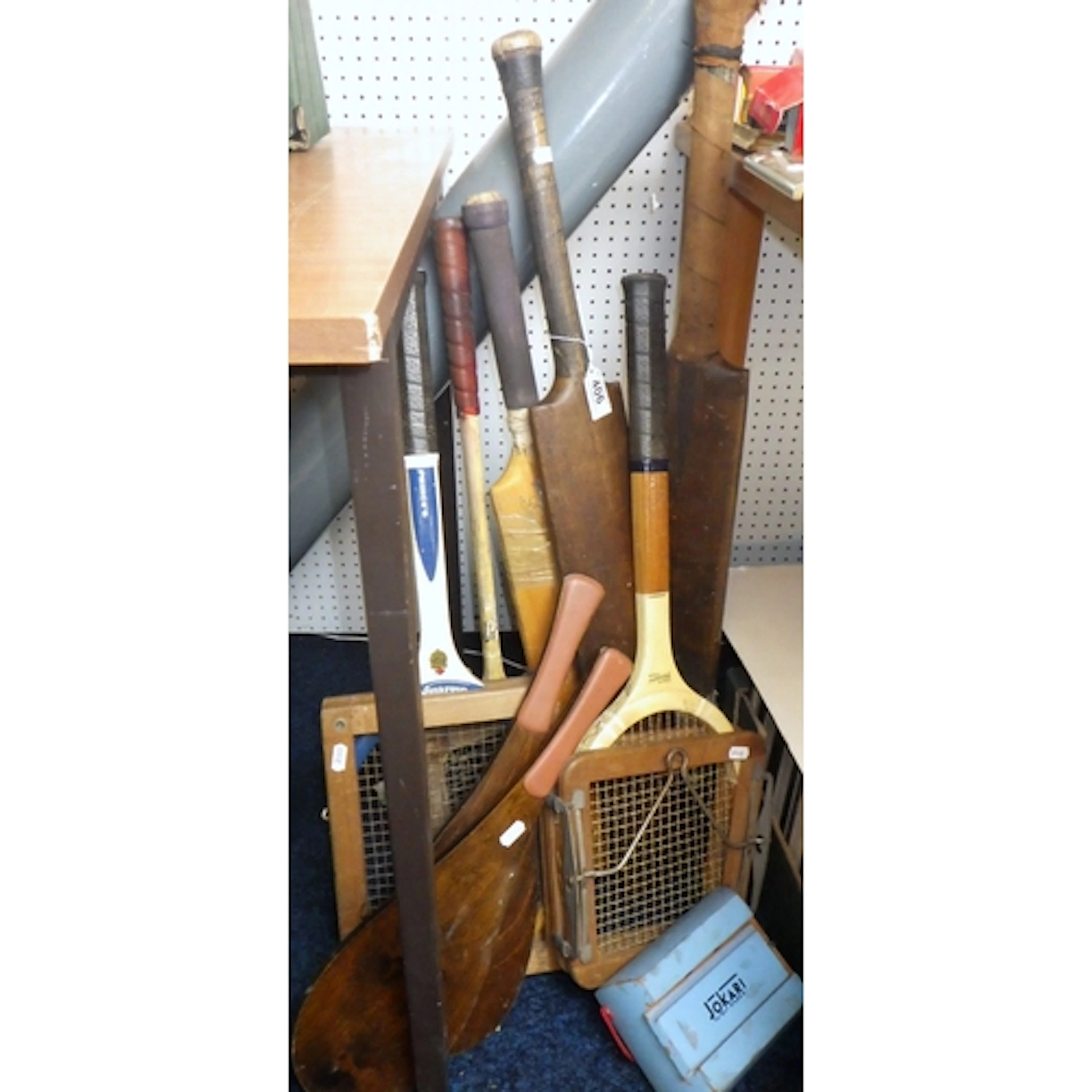 A group of vintage cricket bats, tennis rackets etc