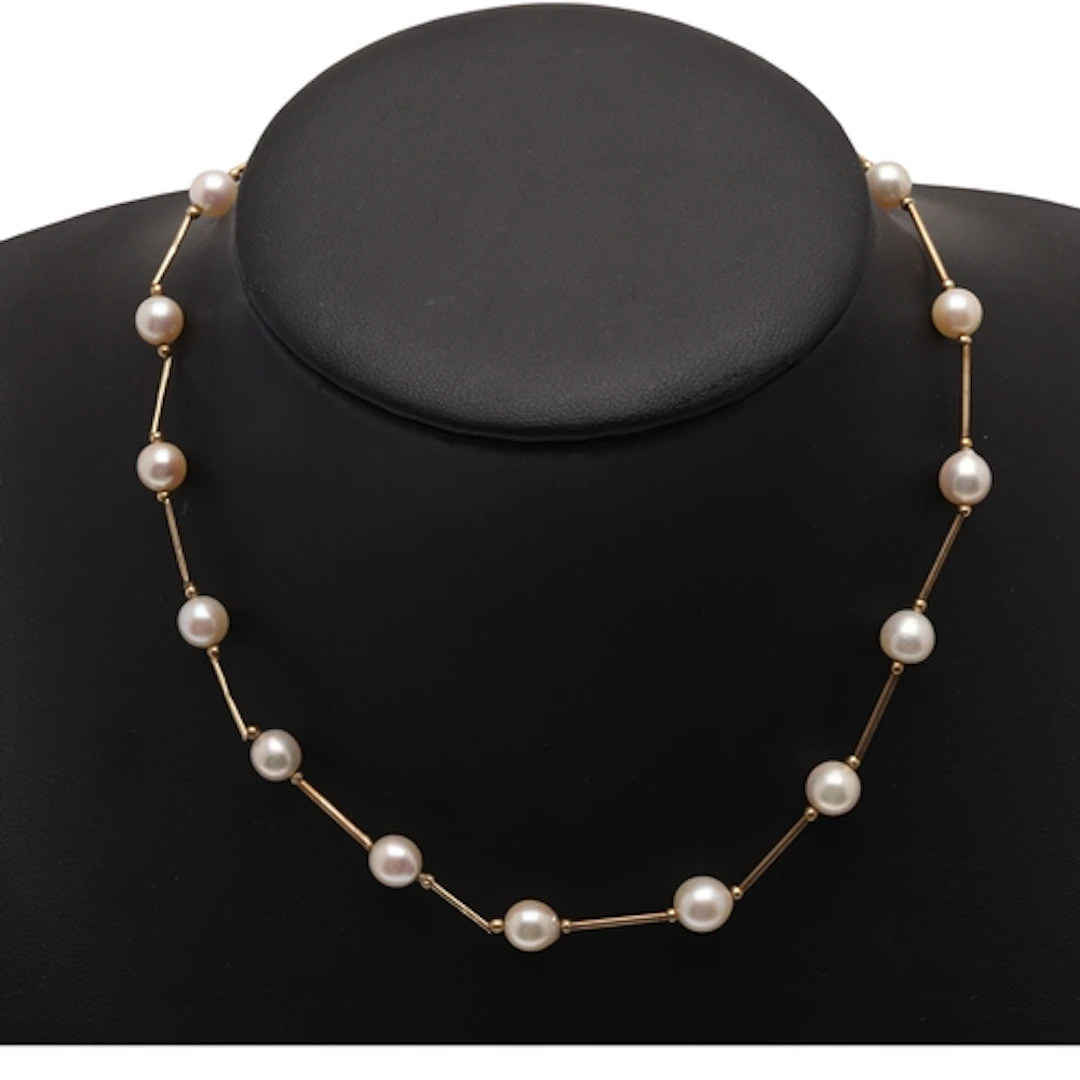 A CULTURED PEARL AND 9CT GOLD NECKLACE. mounted with culture...