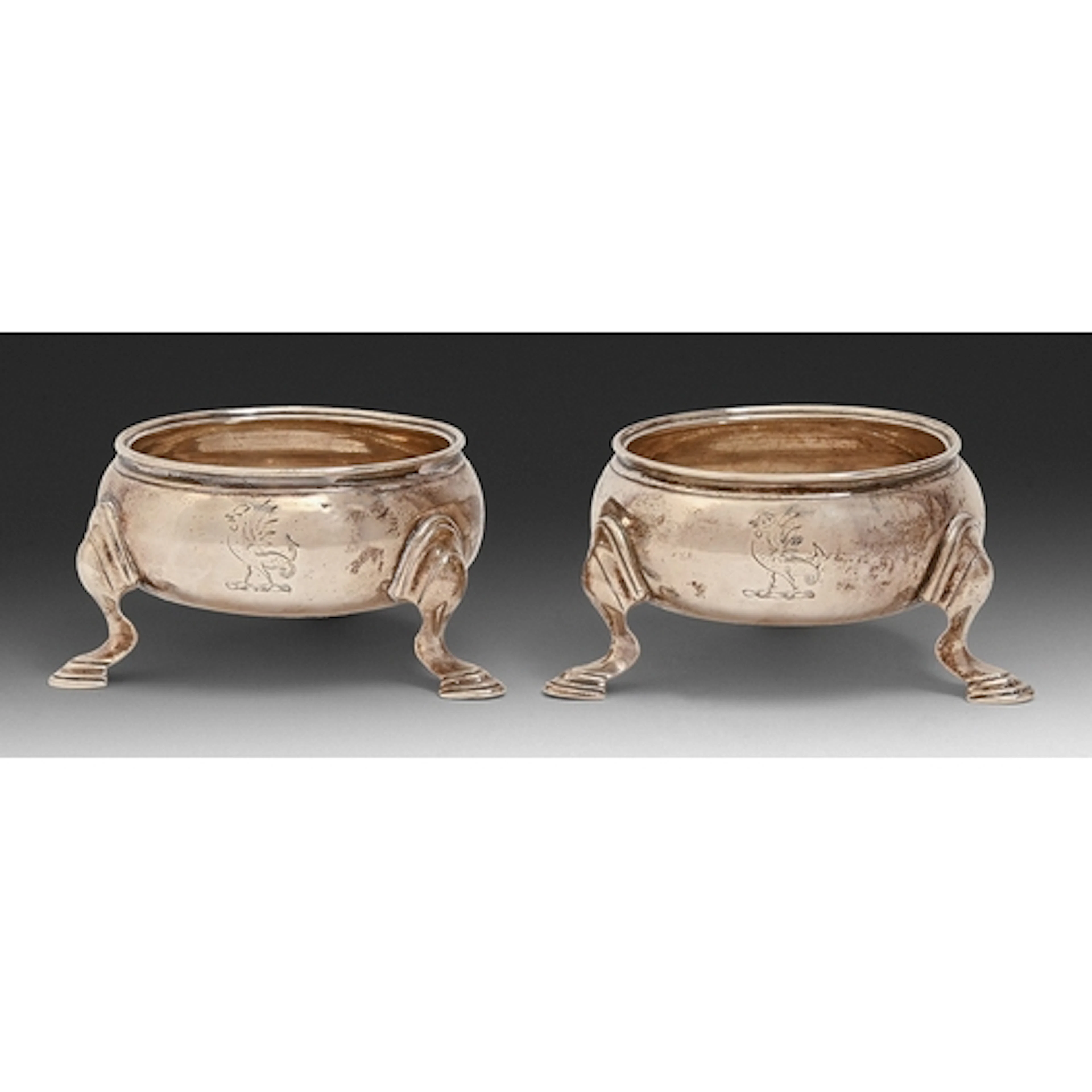 A pair of George II silver salt cellars, on three hoof feet,...