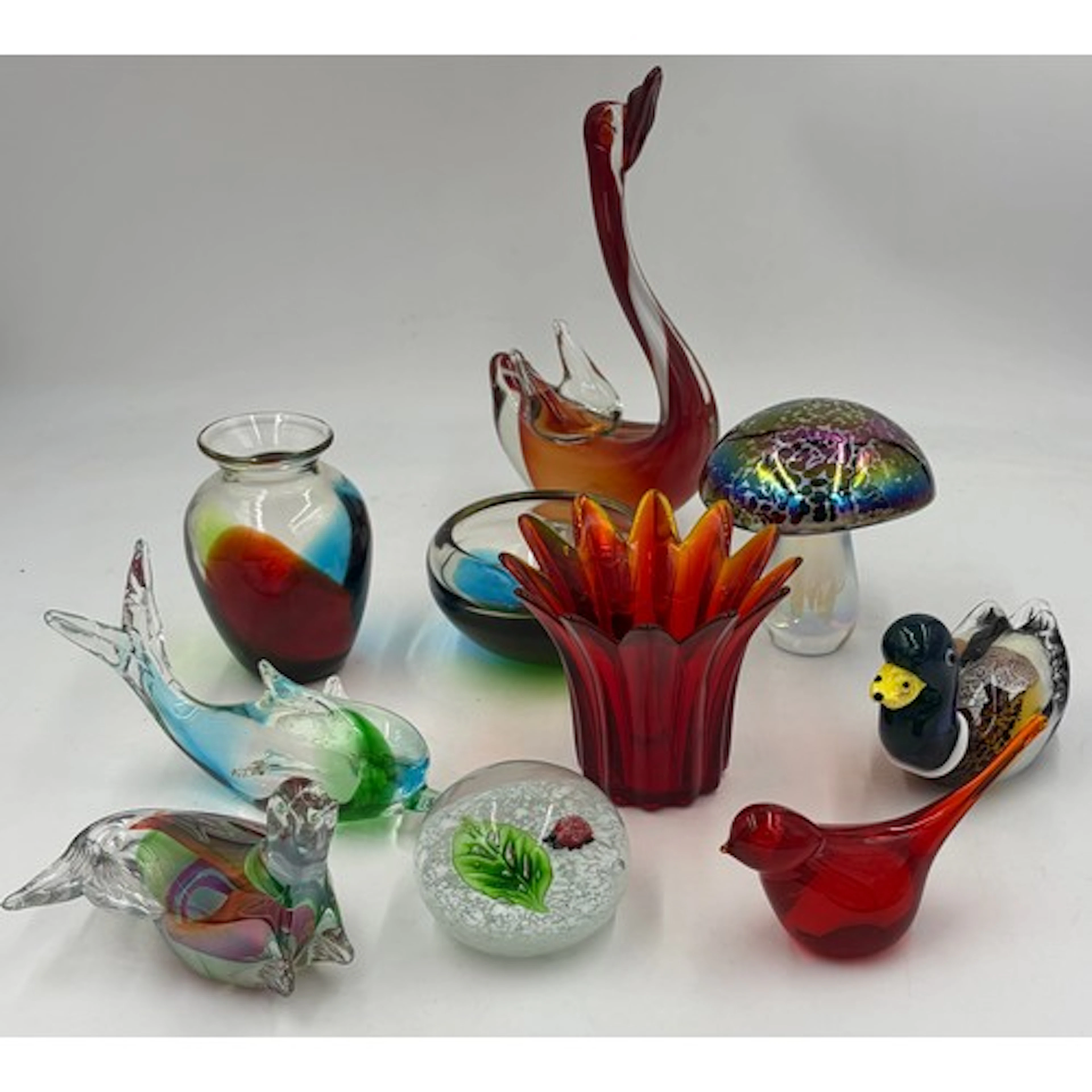A collection of glass paperweights to include iridescent mus...