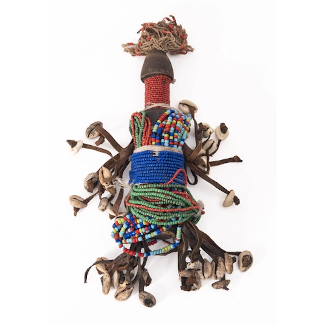 A 20th Century fertility doll with beads and shells and a Br...