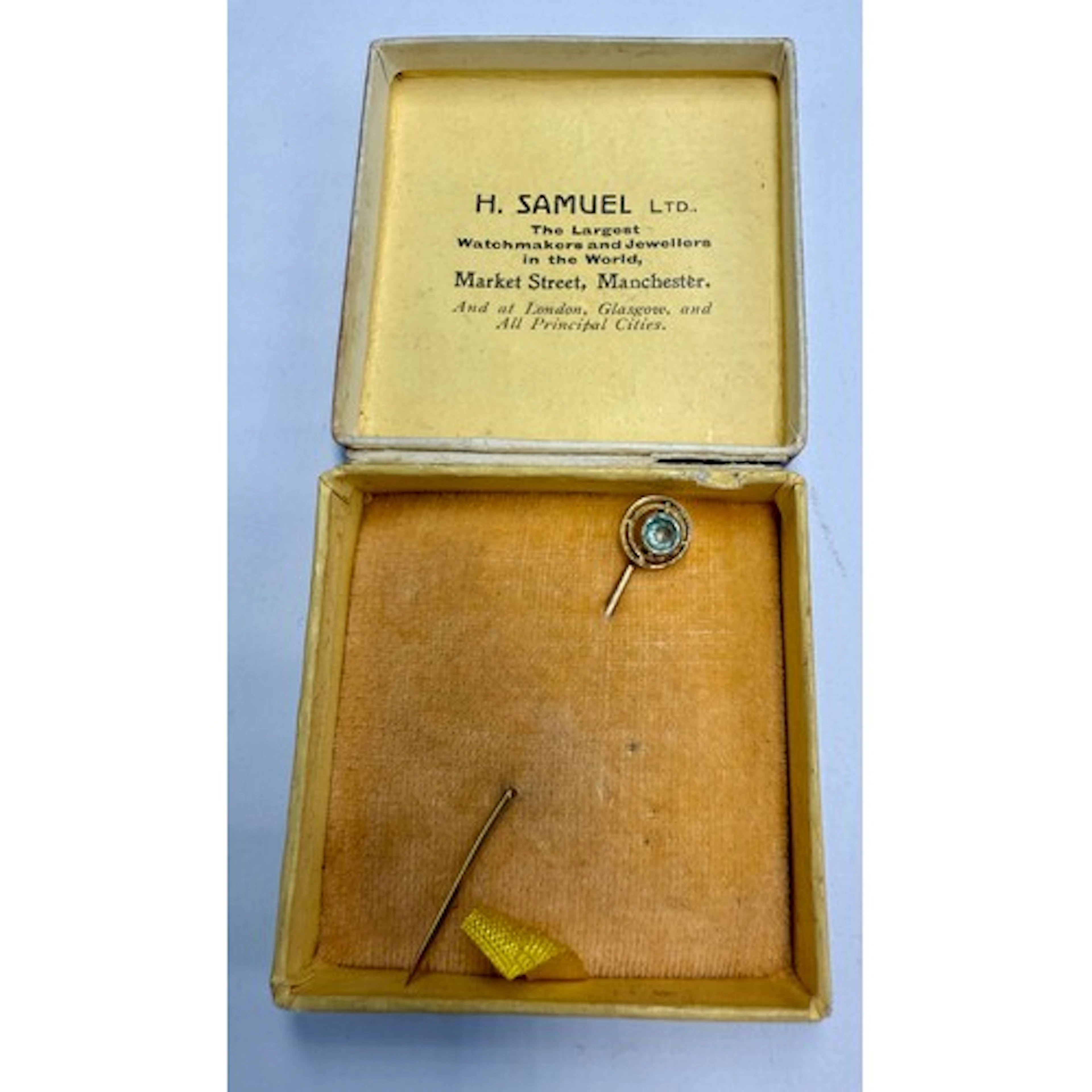 A yellow metal tie pin set with aquamarine, marked indistinc...