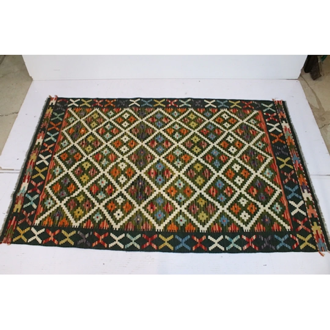 Maimana Kilim rug, having green ground with geometric accent...