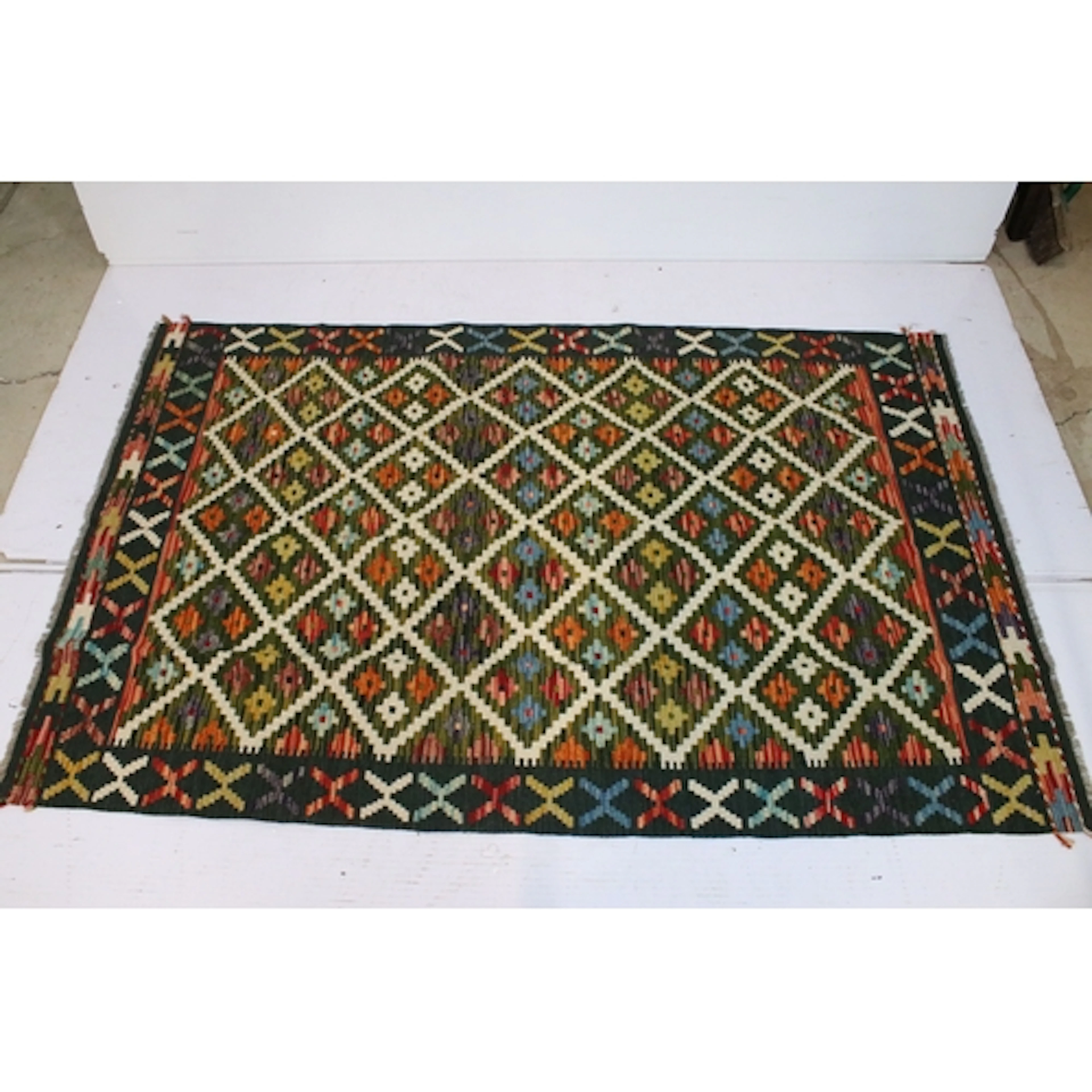 Maimana Kilim rug, having green ground with geometric accent...