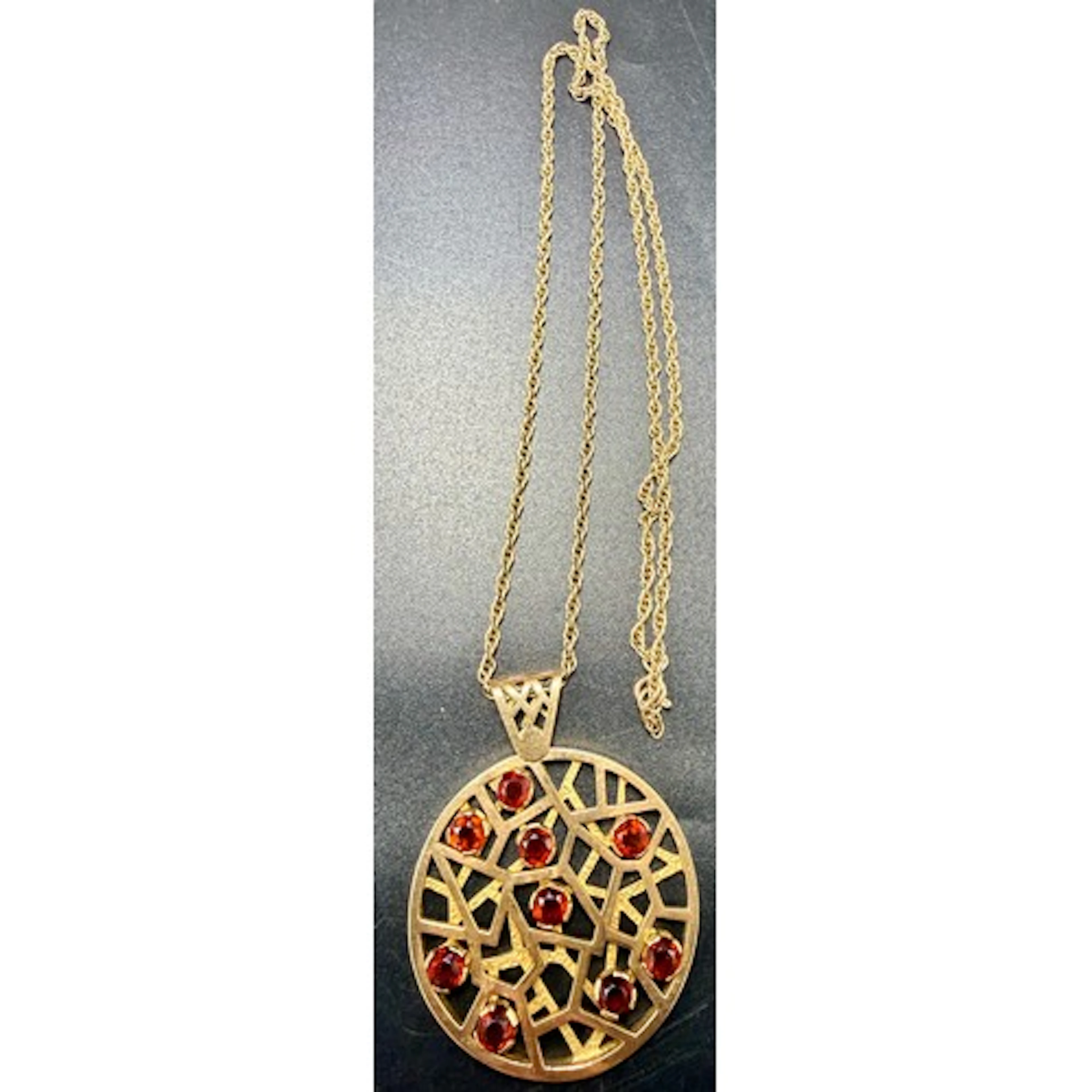 A 9 carat gold pendant and chain, London 1972, set with nine...