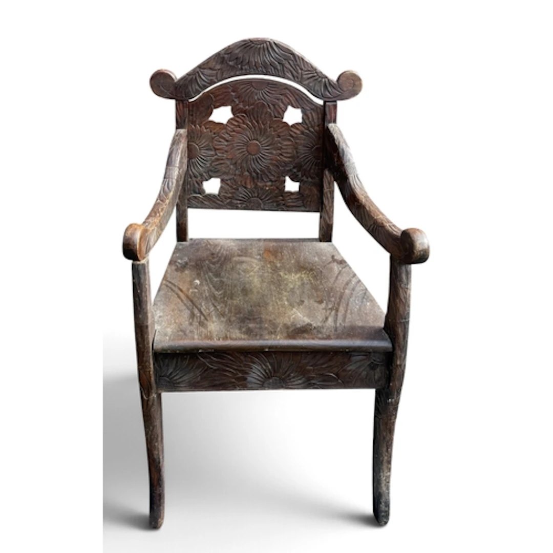 AN ANTIQUE OAK ARMCHAIR WITH CARVED FOLIATE BACK AND SCROLLI...