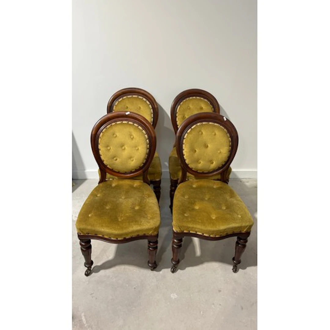 Four upholstered dining chairs with circular backs.