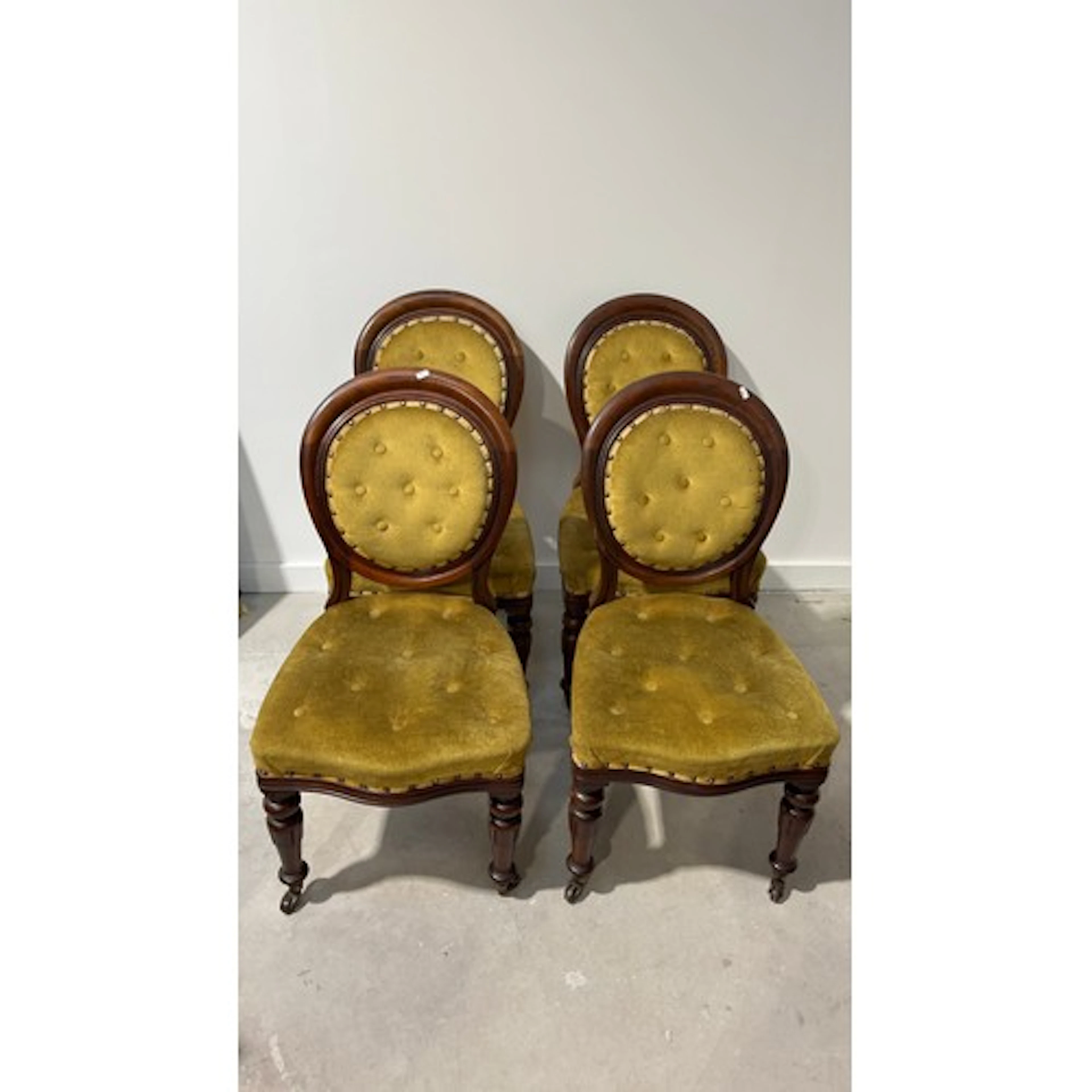 Four upholstered dining chairs with circular backs.