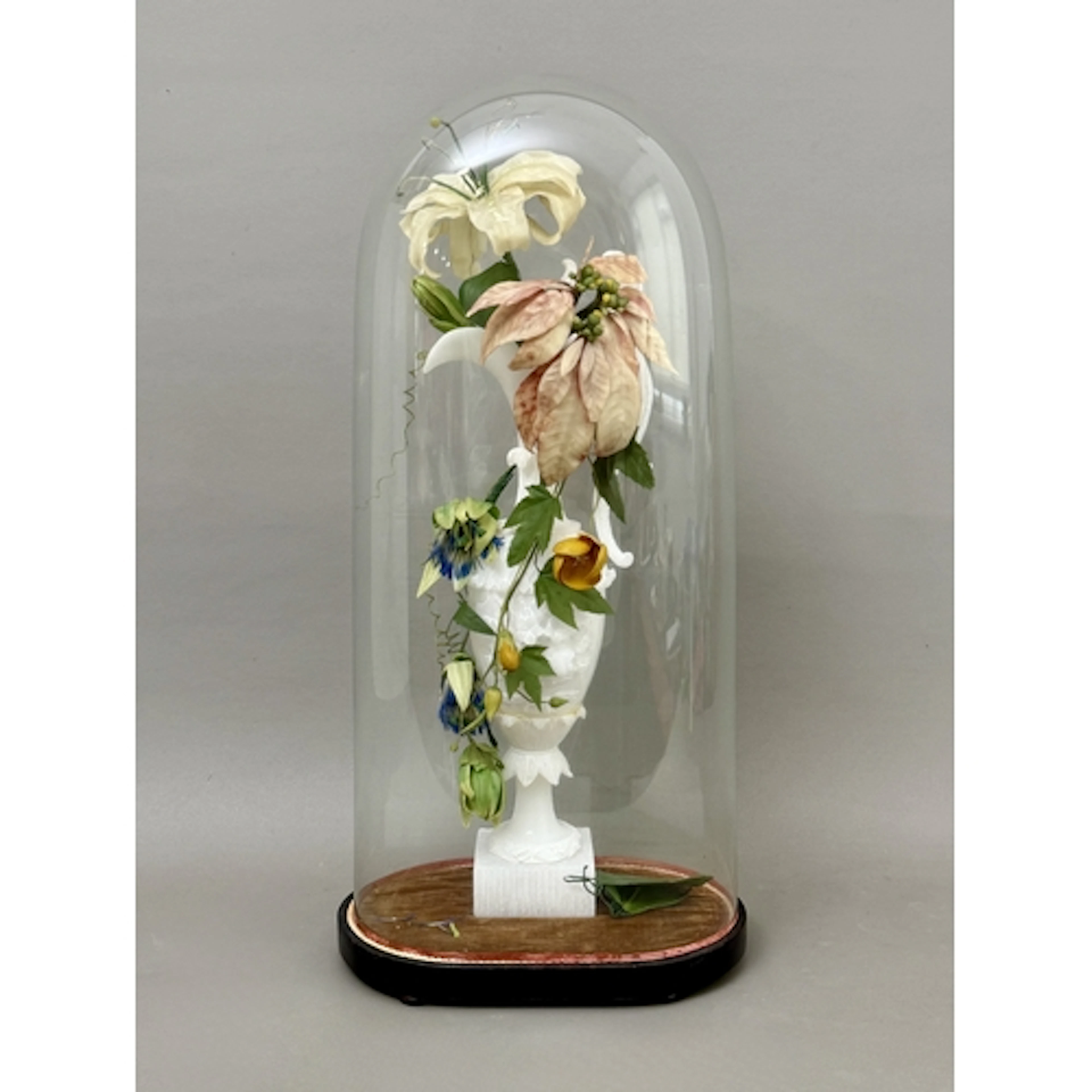 A Victorian carved alabaster ewer beneath a blown glass dome...