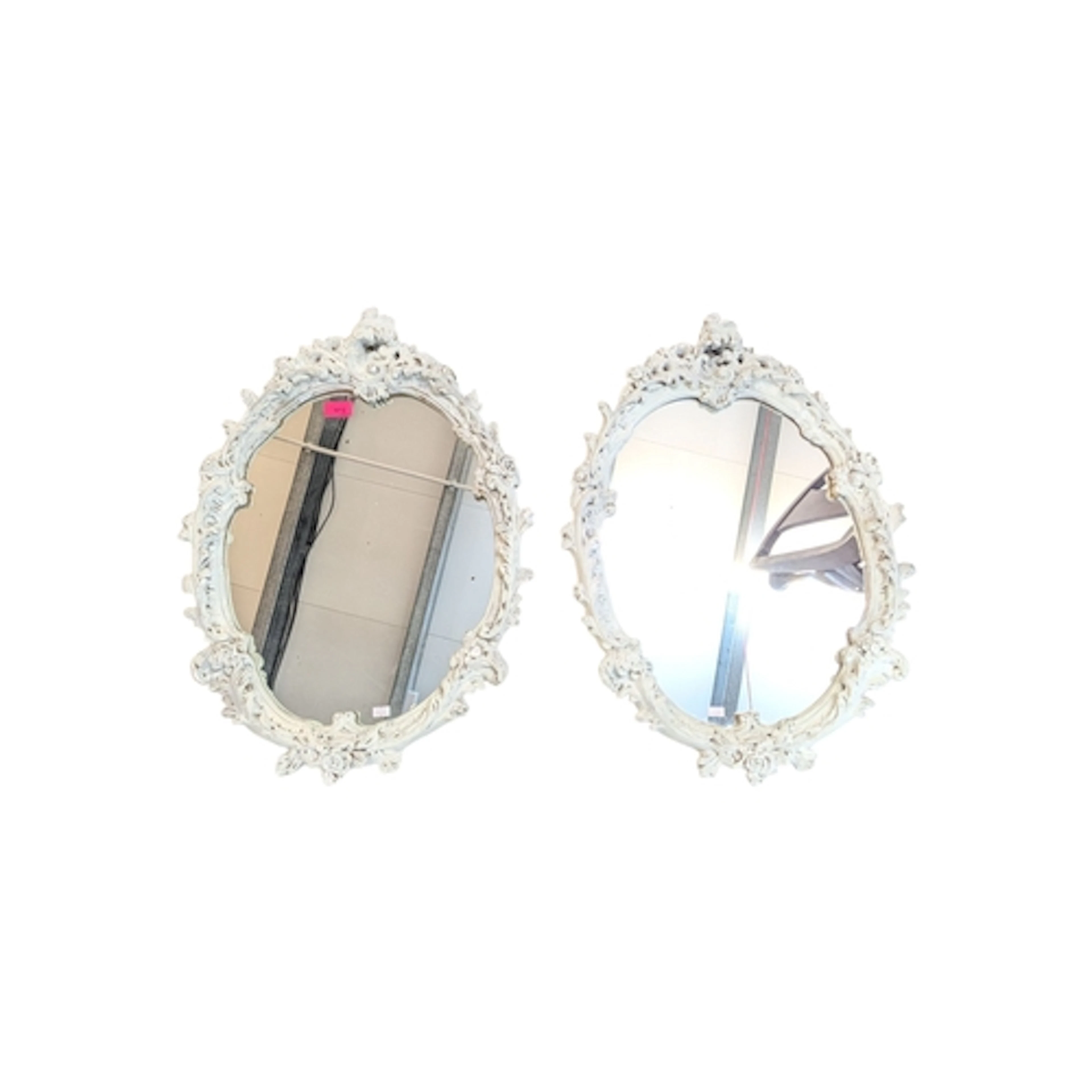 Two 1950s Rococo style white painted wall mirrors. Of oval f...