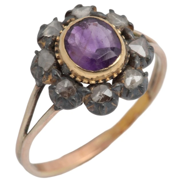 An amethyst and diamond cluster ring, centring on an oval am...
