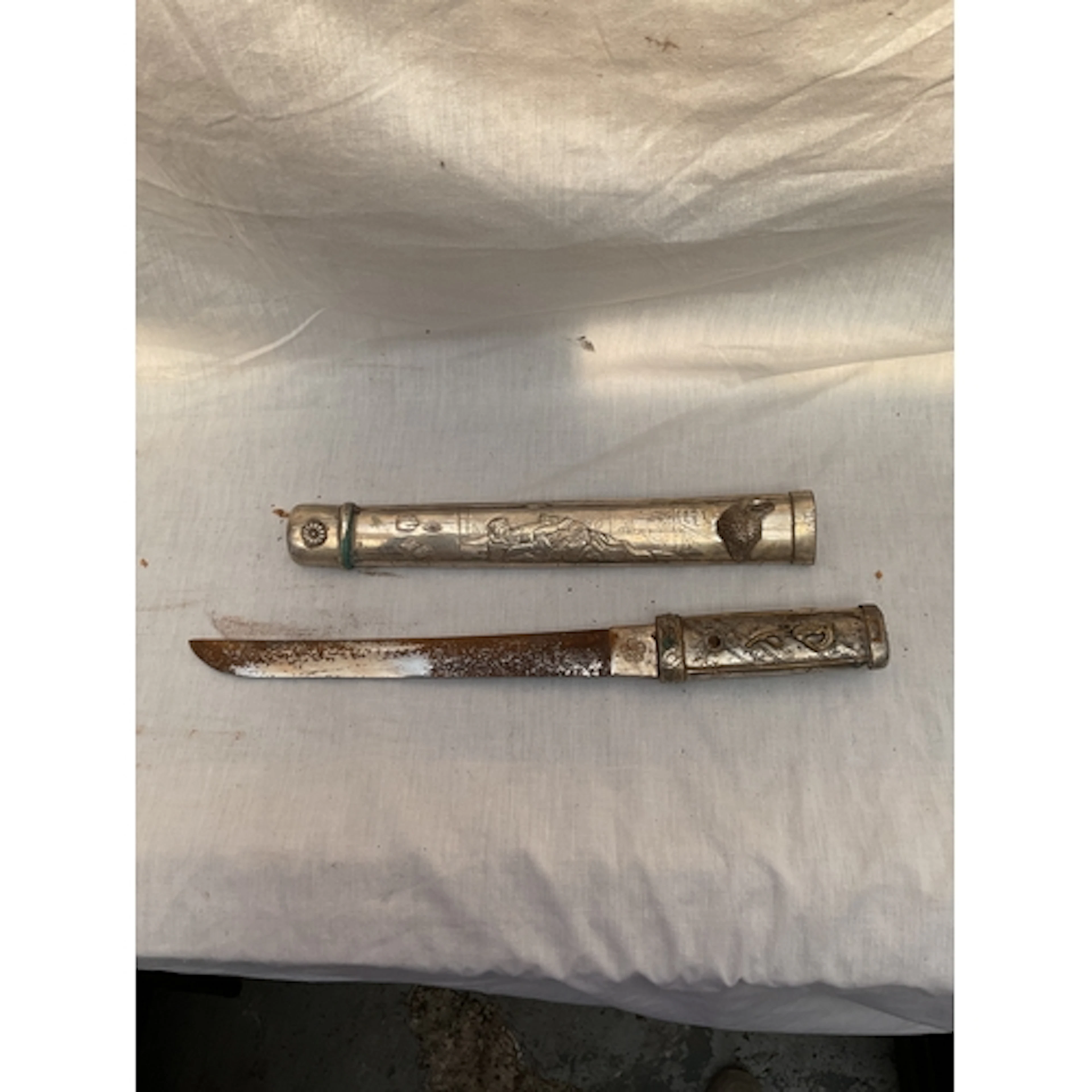 Ornate metal Tanto dagger with erotic scenes.